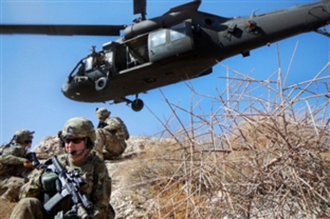 U.S. Army Sgt. Walter Miles, foreground, U.S. Army 2nd Lt. Nick Wahlquist, center left, and U.S. Army Pfc. Kyle O'Brien practice mountaintop landing zone security techniques with a UH-60 Black Hawk helicopter near Kandahar Airfield, Afghanistan, Oct. 14, 2013. Miles, Wahlquist and O'Brien are assigned to the 1st Battalion, 6th Artillery Regiment, 1st Combat Aviation Brigade, and the helicopter crew members are assigned to Company C, 3rd Battalion, 1st Aviation Regiment.