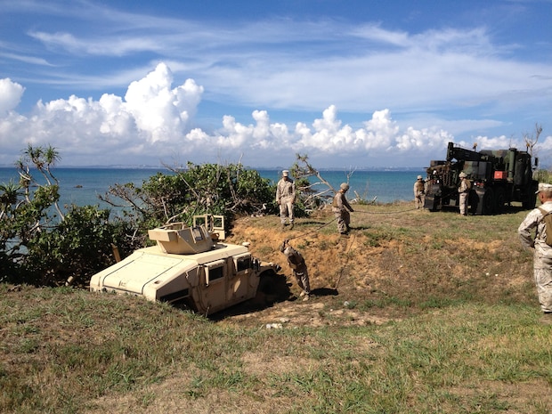 September 12, 2013, GySgt Nicholas Singh, the Vehicle Recovery Section SNCOIC, supervises recovery training during the 3rd Maintenance Battalion Field Exercise 13-2 in the Central Training Area on Okinawa, Japan. During the training, Marines used the AMK36 medium tactical vehicle replacement wrecker to pull an up-armored high-mobility multipurpose wheeled vehicle, which was mired in a ditch. The exercise provided realistic training for the Marines, as they might face these types of situations during real-world operations. Ensuring the proficiency of recovery operators ensures the Marines can operate independently within the Asia-Pacific region. Third Maintenance Battalion is part of Combat Logistics Regiment 35, 3rd Marine Logistics Group, III Marine Expeditionary Force. 