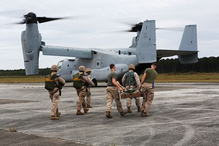 Marines with Air Delivery Platoon, 2nd Marine Logistics Group head towards a MV-22B Osprey with simulated equipment for dropping during an exercise at Tactical Landing Zone Pheasant aboard Camp Lejeune, N.C., Oct. 21, 2013.  Air delivery Marines must complete a jump every quarter to maintain their certification and mission readiness. (U.S. Marine Corps photo by Lance Cpl. Shawn Valosin)