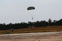 A Marine with Air Delivery Platoon, Landing Support Company, 2nd Marine Logistics Group joins his fellow Marines on the ground during an air delivery exercise at Tactical Landing Zone Pheasant aboard Camp Lejeune, N.C., Oct. 21, 2013. This exercise was used to renew jump certifications and maintain mission readiness. (U.S Marine Corps photo by Lance Cpl. Shawn Valosin)