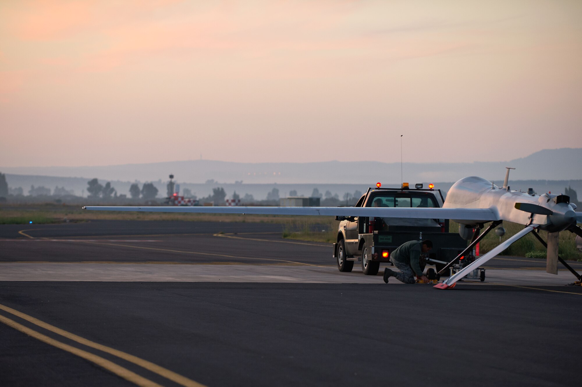 Airmen attached to the 324th Expeditionary Reconnaissance Squadron perform a preflight inspection on an MQ-1 Predator unmanned aerial vehicle Oct. 22, 2013. (U.S. Navy photo/Mass Communication Specialist 2nd Class Brian T. Glunt)