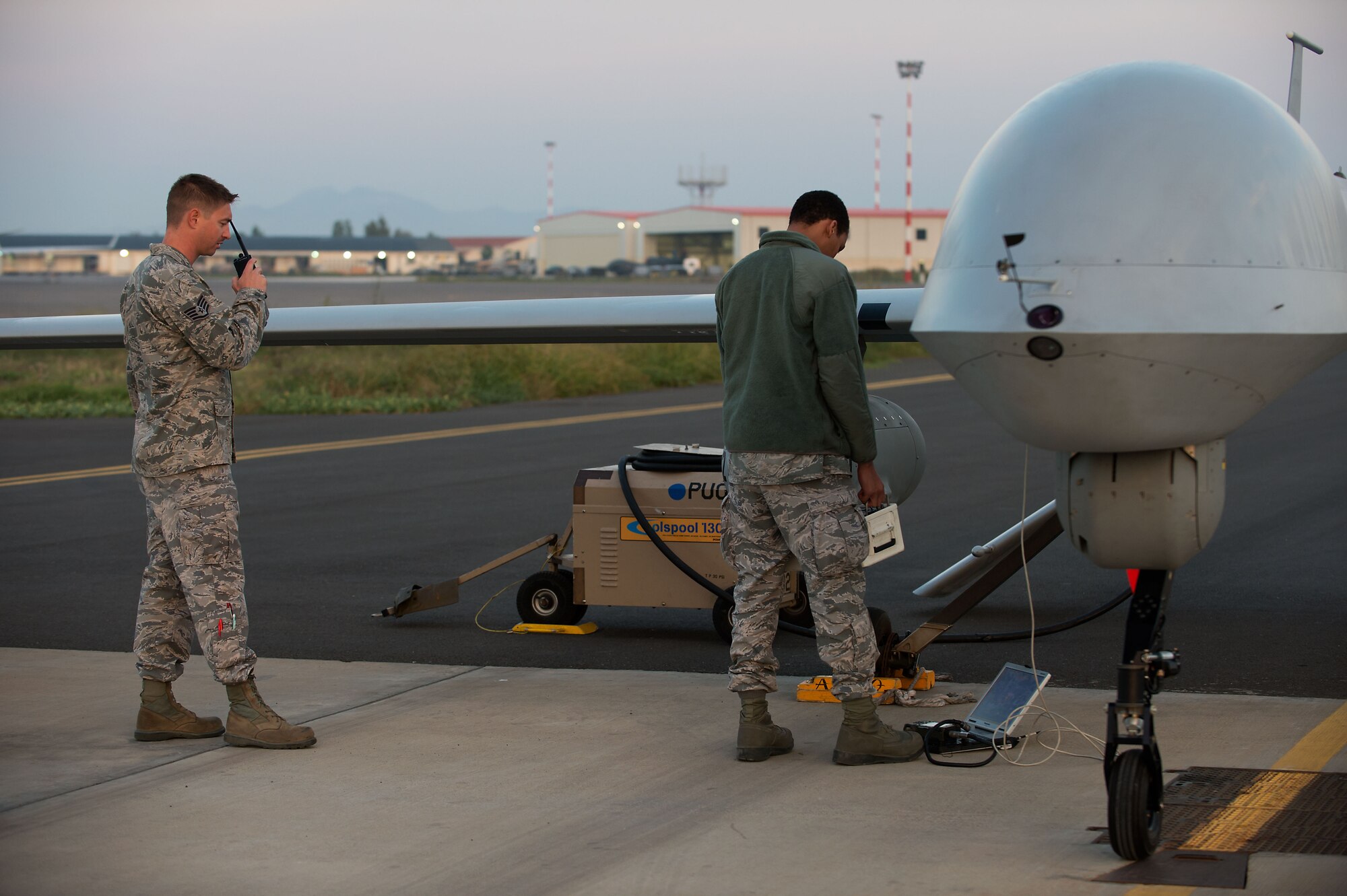 Airmen attached to the 324th Expeditionary Reconnaissance Squadron perform a preflight inspection on an MQ-1 Predator unmanned aerial vehicle Oct. 22, 2013. (U.S. Navy photo/Mass Communication Specialist 2nd Class Brian T. Glunt)