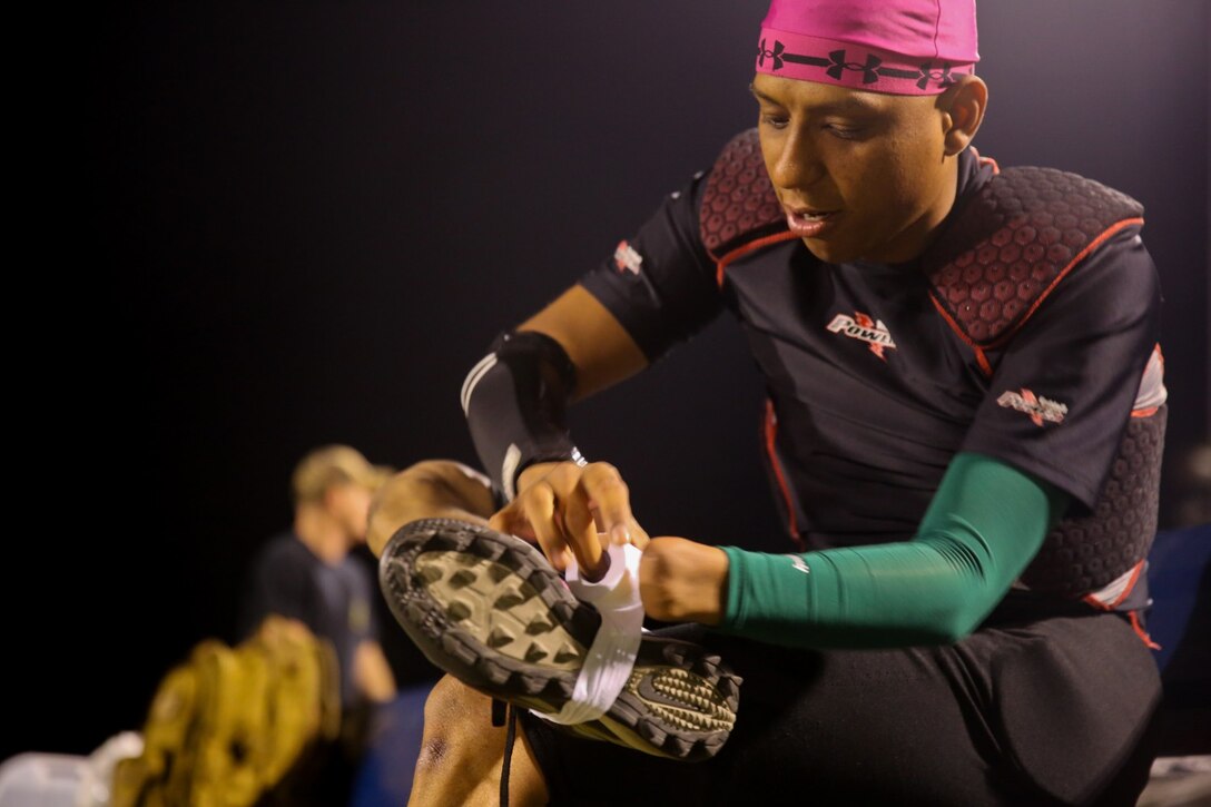 Sergeant Ricardo Ramirez, squad leader, 3rd Battalion, 5th Marine Regiment, tapes his cleats in preparation for a football game here, Oct. 21, 2013. Ramirez lost his hand during combat operations while serving with 3rd Battalion, 5th Marines, in support of Operation Iraqi Freedom, Feb. 22, 2006. He currently still supports his former battalion while attached to 5th Marines and plays cornerback and special teams on the Fighting Fifth's football team.