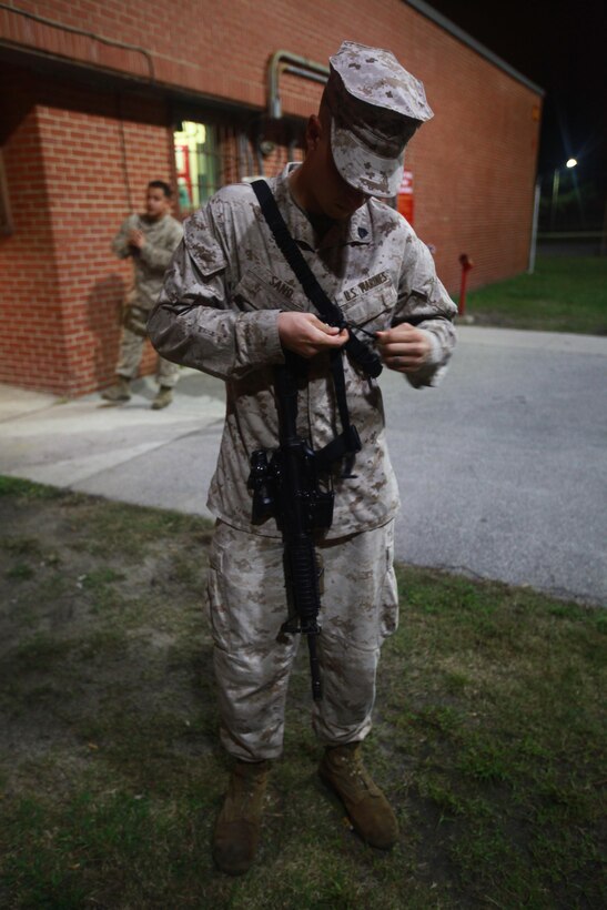 Sgt. Andrew M. Sand, a motor transport mechanic with Marine Wing Support Squadron 274, attached a three-point sling to his rifle before heading to the terminal for departure to Twentynine Palms, Calif. Oct. 16.