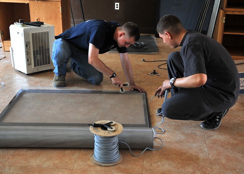 Airman 1st Class Zackery Stroup, left, and Airman Alexander Carroll, both 51st Security Forces Squadron force protection members, re-screen a window during the “Worst Dorm First” renovation of Bldg. 1436 at Osan Air Base, Republic of Korea, Oct. 23, 2013. Dorm residents, along with help from the 51st Civil Engineer Squadron Structures Shop, re-screened a total of 28 windows. (U.S. Air Force photo/Airman 1st Class Ashley J. Thum)