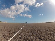 Members of the 647th Civil Engineer Squadron Structures Flight paint the first-ever assault landing zone at the Navy’s Barking Sands Pacific Missile Range Facility on the island of Kauai. The ability to practice assault landings on a short or austere runway is a critical skill C-17 pilots must practice in order to effectively execute the C-17’s mission of worldwide airlift, during peacetime and war, in support of national security and the Department of Defense. (Courtesy photo)