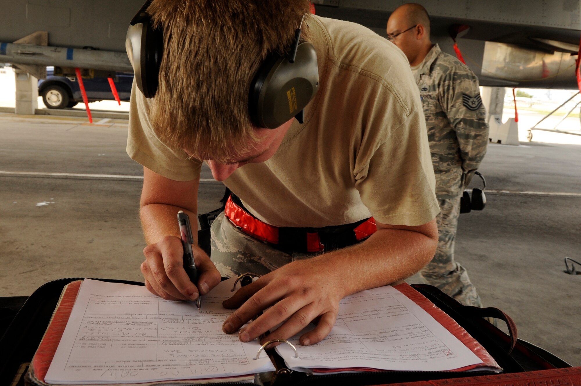 U.S. Air Force Airman 1st Class Zachary Ross, 67th Aircraft Maintenance Unit weapons load crew member, annotates his checklist during a quarterly weapons load competition at Kadena Air Base, Japan, Oct. 18, 2013. The teams were inspected on safety, reliability and technical orders of loading the F-15 Eagle. (U.S. Air Force photo by Senior Airman Marcus Morris)