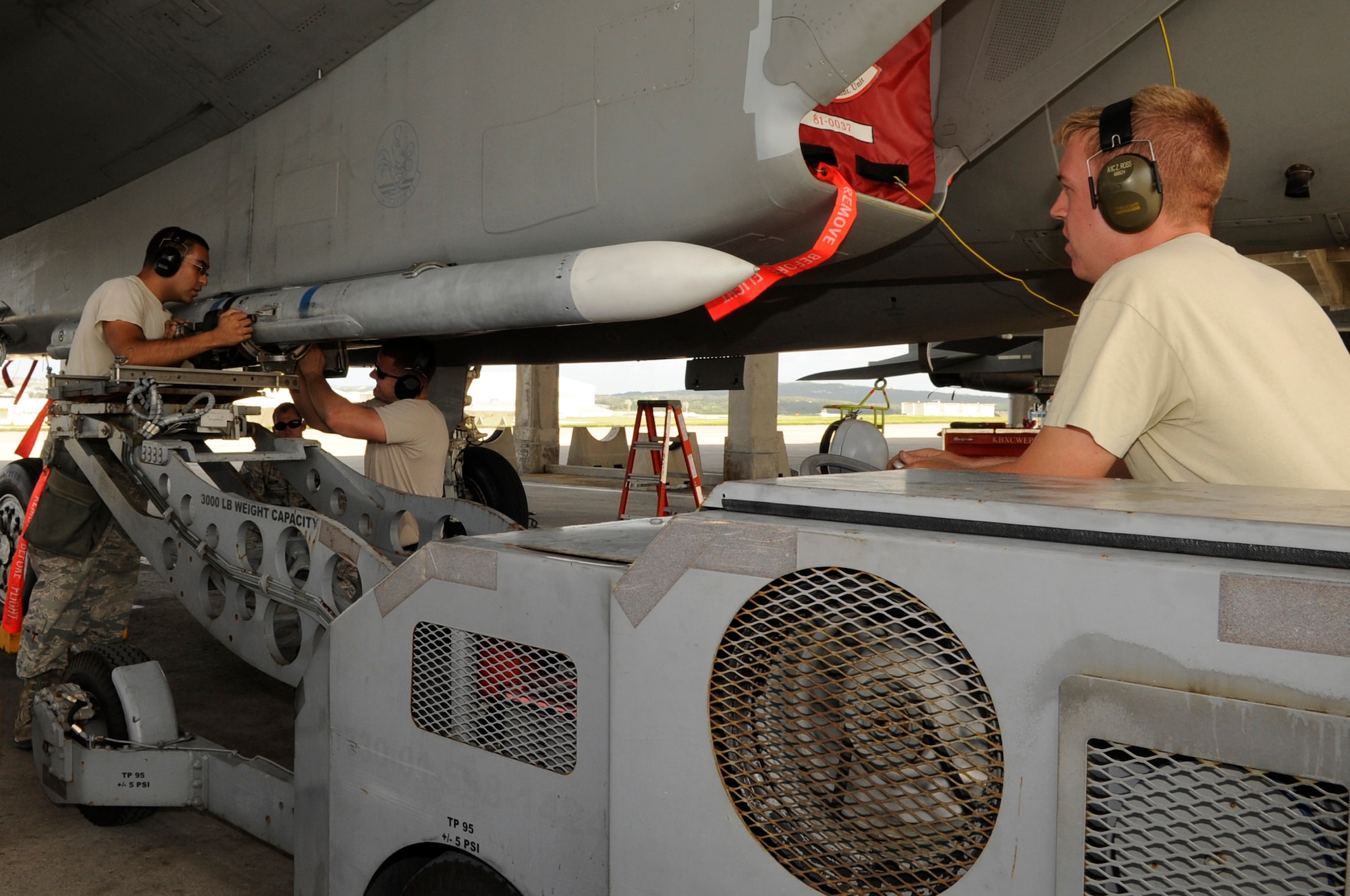 U.S. Air Force 67th Aircraft Maintenance Unit weapons load crew members attach a missile onto an F-15 Eagle during a weapons load competition at Kadena Air Base, Japan, Oct. 18, 2013. The 67th AMU beat the 44th Aircraft Maintenance Unit by being the quickest team to load weapons onto an F-15 Eagle with the fewest errors. (U.S. Air Force photo by Senior Airman Marcus Morris)