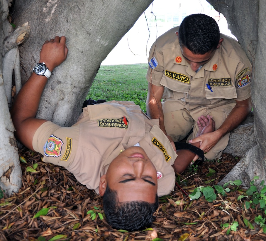 A Honduran firefighter attends to a "victim" as part of a basic life support class conducted at Soto Cano Air Base, Honduras, Oct. 23, 2013.  Members of Joint Task Force-Bravo's Medical Element (MEDEL) trained 19 local firefighters in basic life support skills.  (U.S. Air Force photo by Capt. Zach Anderson)