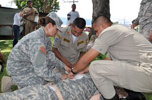 U.S. Army Specialist Lourdes Tarin, an emergency medical technician assigned to Joint Task Force-Bravo, instructs Honduran firefighters on the proper care for a victim as part of a basic life support class conducted at Soto Cano Air Base, Honduras, Oct. 23, 2013.  Members of Joint Task Force-Bravo's Medical Element (MEDEL) trained 19 local firefighters in basic life support skills.  (U.S. Air Force photo by Capt. Zach Anderson)