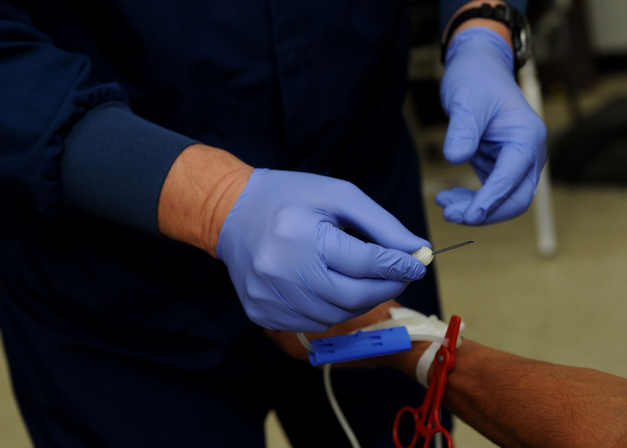 Jeff Griffith, United Blood Services assistant donor care supervisor, prepares to draw blood from a donor during a blood drive conducted by United Blood Services in the 28th Maintenance Squadron at Ellsworth Air Force Base, S.D., Oct. 18, 2013. With more than 25 Airmen donating throughout the day, UBS was able to collect over three gallons of blood. (U.S. Air Force Photo by Airman 1st Class Rebecca Imwalle/ Released)