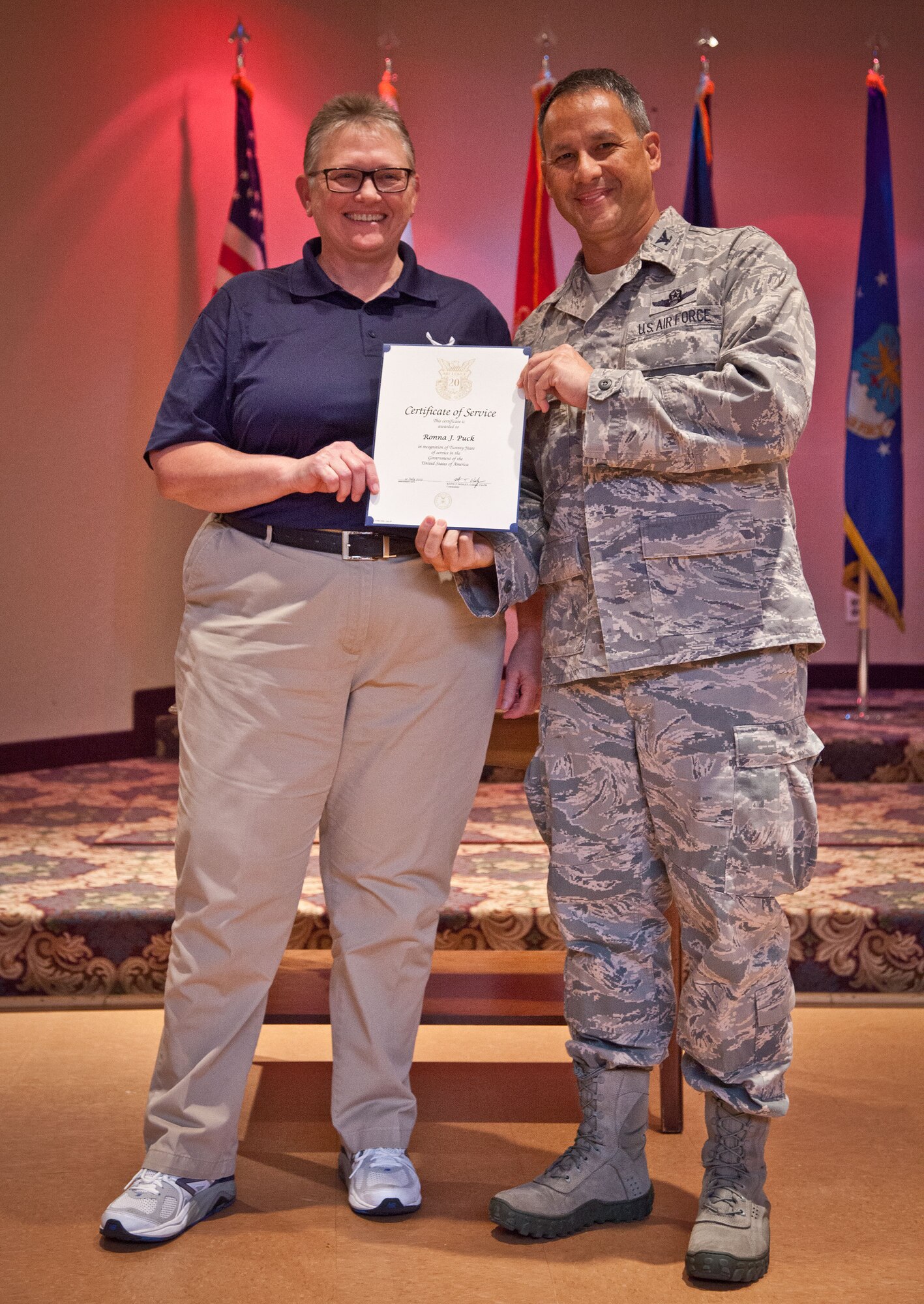 Col. Todd McCubbin, 934th Airlift Wing commander, presents Ronna Puck with her Employee Service Award for 20 years of service during the Civilian Commander's Call at the Services Club at Minneapolis-St. Paul Air Reserve Station, Minn.  (U.S. Air Force photo/Shannon McKay)