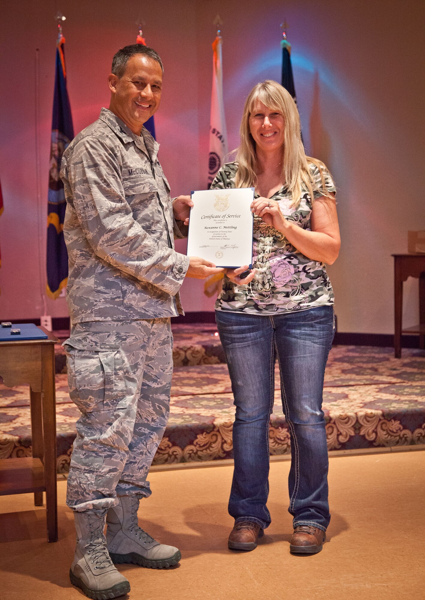 Col. Todd McCubbin, 934th Airlift Wing commander, presents Roxanne Mettling with  her Employee Service Award for 20 years of service during the Civilian Commander's Call at the Services Club at Minneapolis-St. Paul Air Reserve Station, Minn.  (U.S. Air Force photo/Shannon McKay)