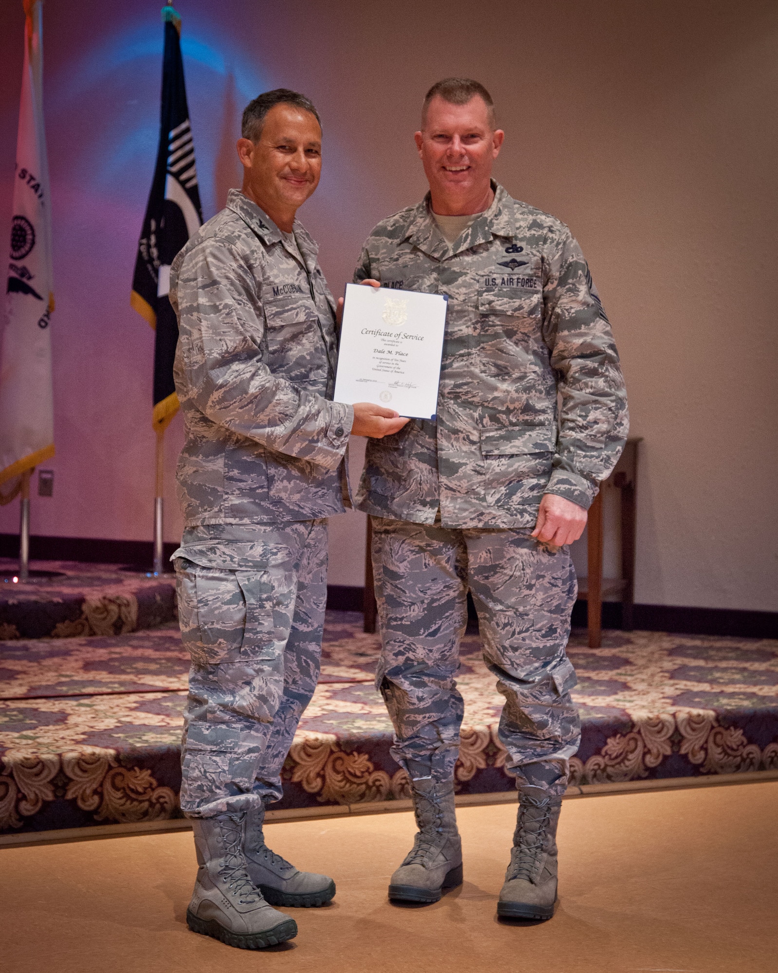 Col. Todd McCubbin, 934th Airlift Wing commander, presents Chief Master Sgt. Dale Place with his Employee Service Award for 10 years of service during the Civilian Commander's Call at the Services Club at Minneapolis-St. Paul Air Reserve Station, Minn.  (U.S. Air Force photo/Shannon McKay)