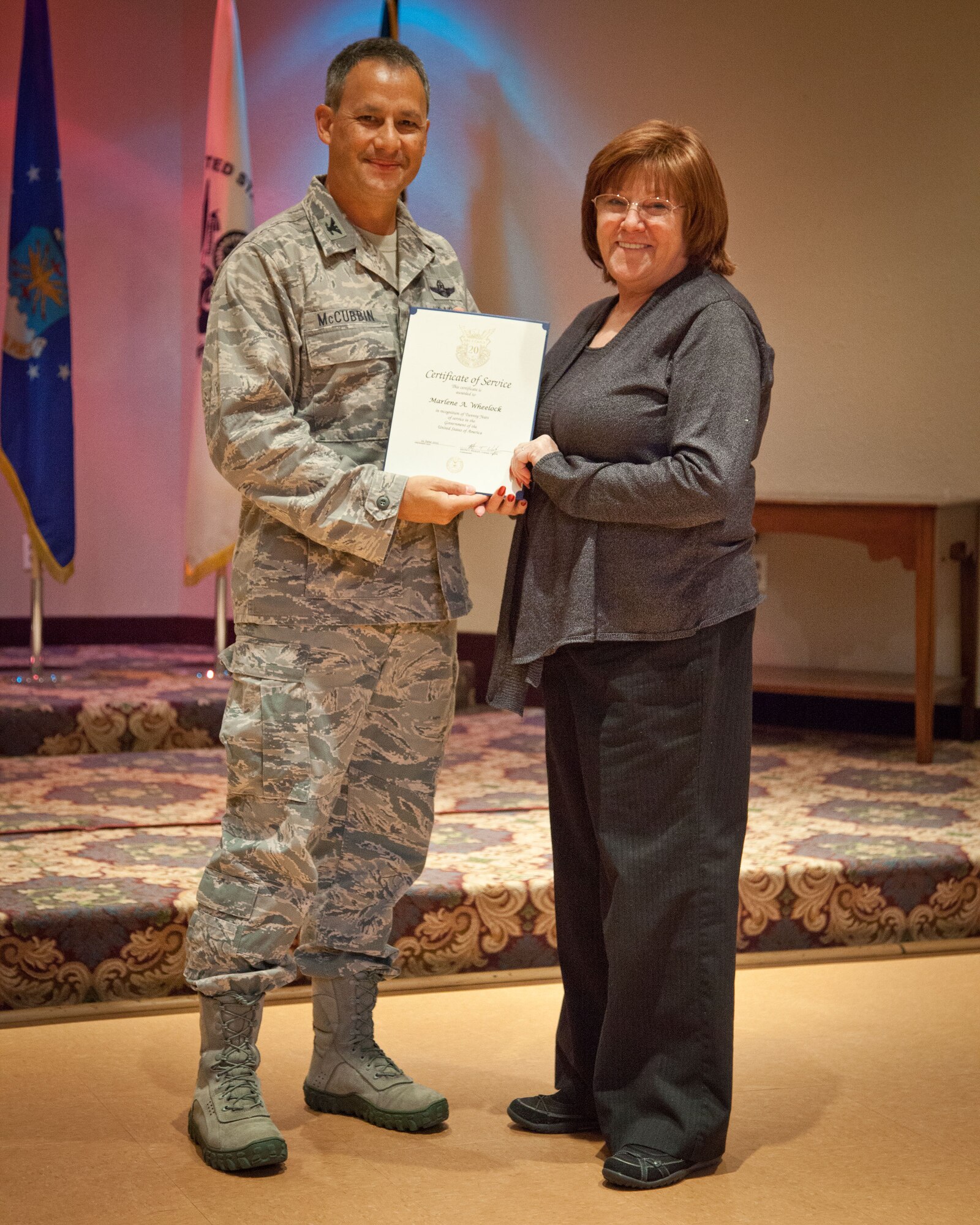 Col. Todd McCubbin, 934th Airlift Wing commander, presents Marlene Wheelock with her Employee Service Award for 20 years of service during the Civilian Commander's Call at the Services Club at Minneapolis-St. Paul Air Reserve Station, Minn.  (U.S. Air Force photo/Shannon McKay)