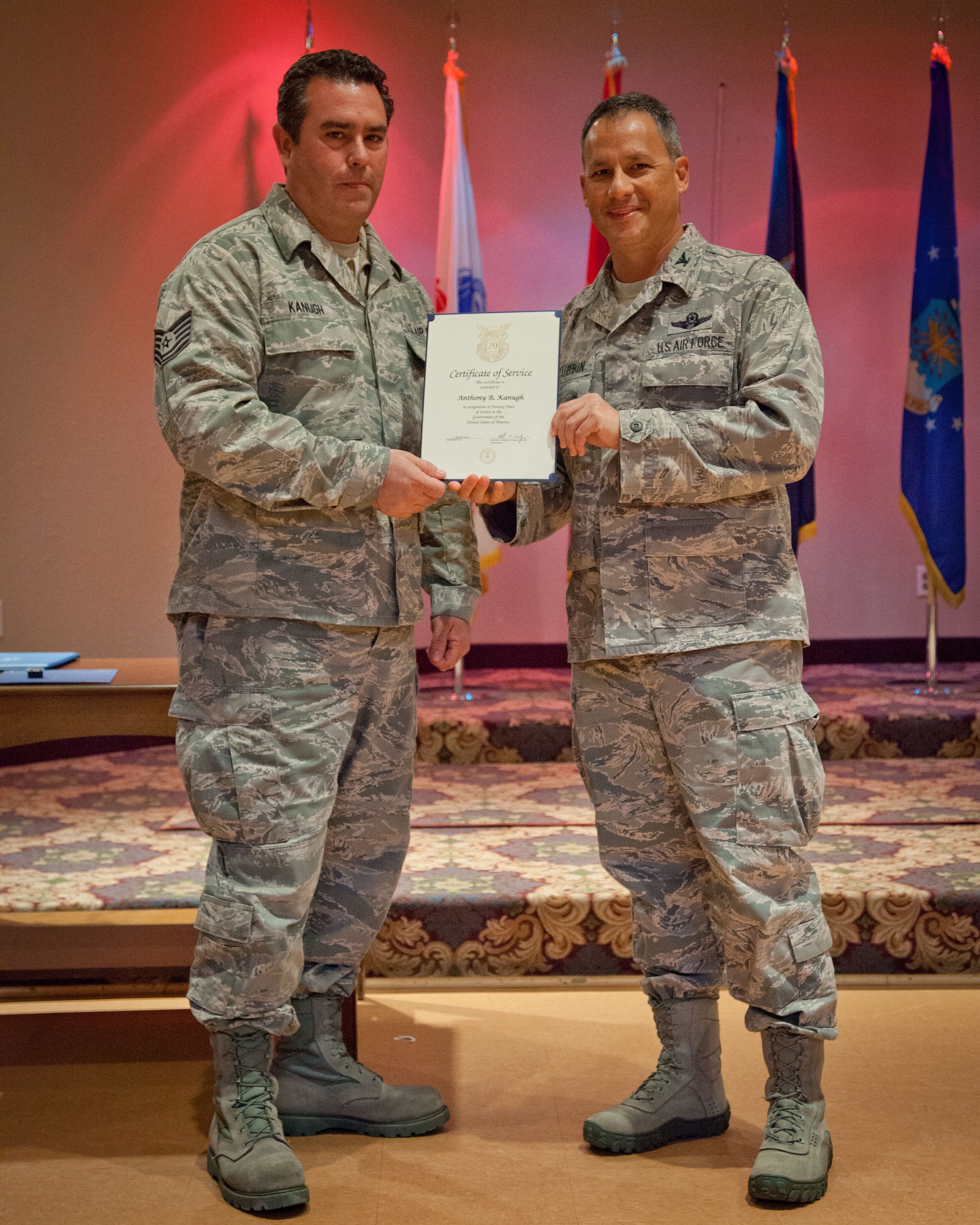 Col. Todd McCubbin, 934th Airlift Wing commander, presents Tech. Sgt. Anthony Kanugh with his Employee Service Award for 20 years of service during the Civilian Commander's Call at the Services Club at Minneapolis-St. Paul Air Reserve Station, Minn.  (U.S. Air Force photo/Shannon McKay)