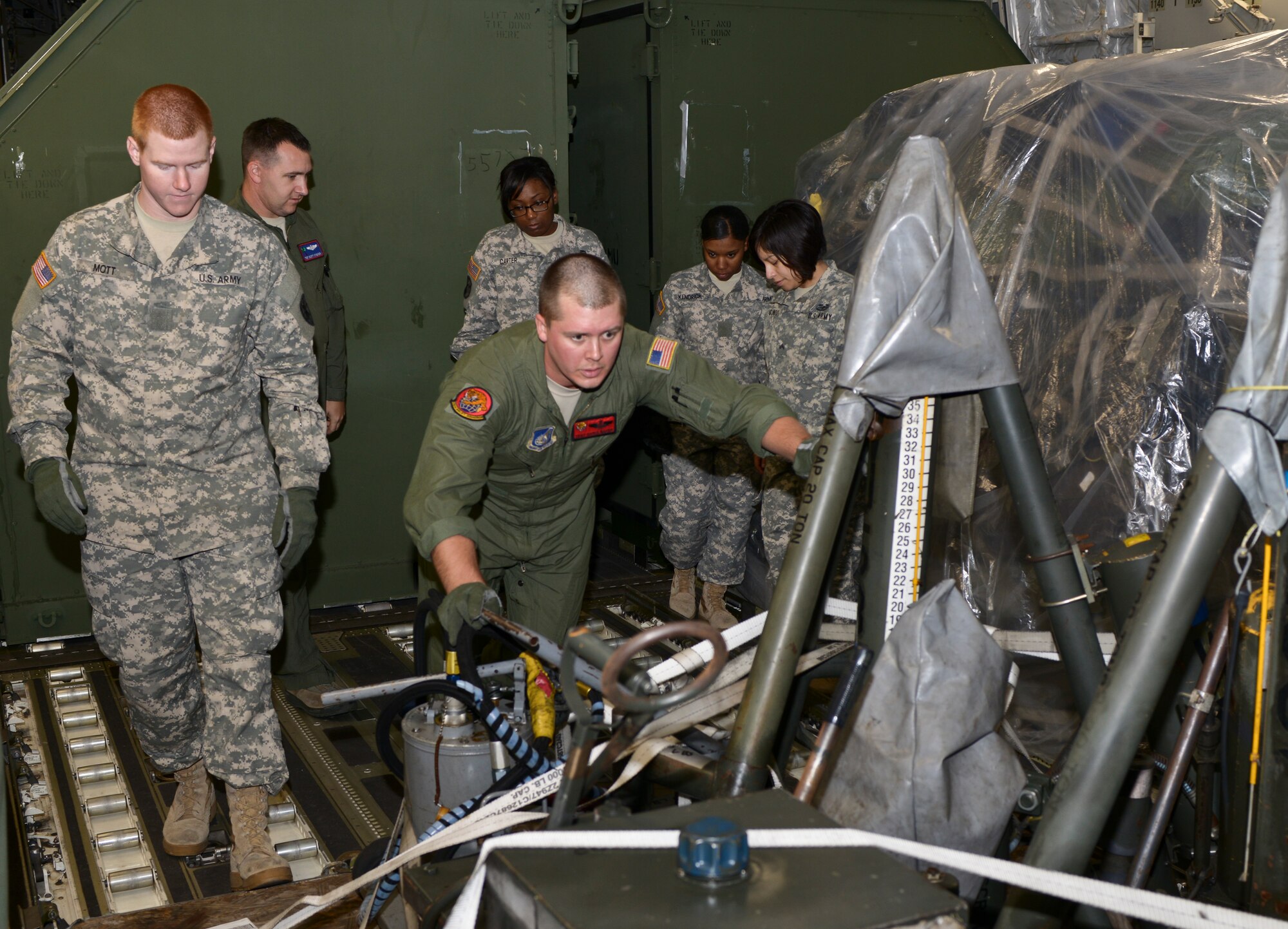 U.S. Air Force Tech. Sgt. Chris Baker, 535th Airlift Squadron loadmaster, pushes an aircraft jack stand out of a C-17 Globemaster III at Langley Air Force Base Va., Oct. 23, 2013. Baker, assigned to Joint Base Pearl Harbor-Hickam, Hawaii, was part of a crew who helped Soldiers from the 622nd Movement Control Team from Fort Eustis, Va., to gain large airframe training alongside Langley Airmen. (U.S. Air Force photo by Senior Airman Connor Estes/Released)