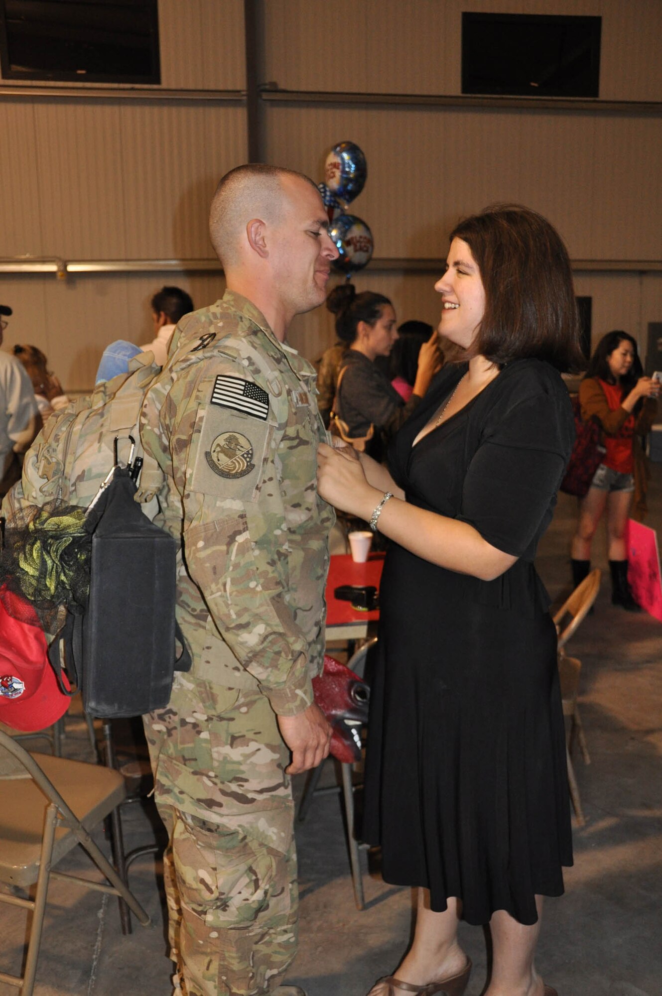 NELLIS AIR FORCE BASE, Nev. -- (Left) Tech. Sergeant Richard Vagnoni, 555th RED HORSE Squadron, is welcomed home to Nellis Air Force Base, Nev., by his wife Oct. 22 after a six-month deployment to Southwest Asia. The squadron deployed more than 30 members to various locations in the region where they repostured and dispositioned assets, and closed down camp sites, among other retrograde efforts. Rapid Engineer Deployable Heavy Operational Repair Squadron Engineers provide a mobile, self-sufficient force responsible for heavy repair and construction in remote environments. (U.S. Air Force photo/Maj. Jessica Martin)