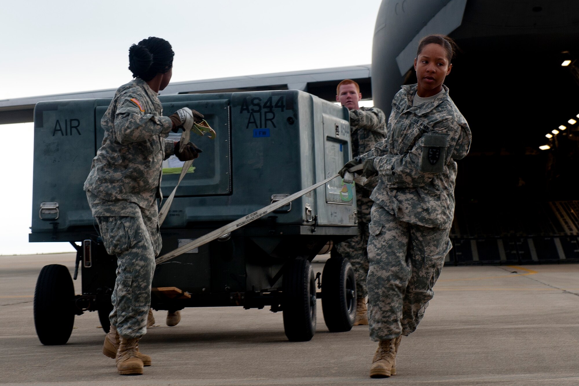 U.S. Army Pfc. Angelika Lundy, left, and Pvts. Christopher Mott, center, and Keiriston Anderson, right, from the 622nd Movement Control Detachment, unload equipment from a C-17 Globemaster III at Langley Air Force Base, Va., Oct. 23, 2013. The 622nd MCD is a part of the Army Departure Airfield Control Group, based at Fort Eustis, Va. (U.S. Air Force photo by Staff Sgt. John D. Strong II)