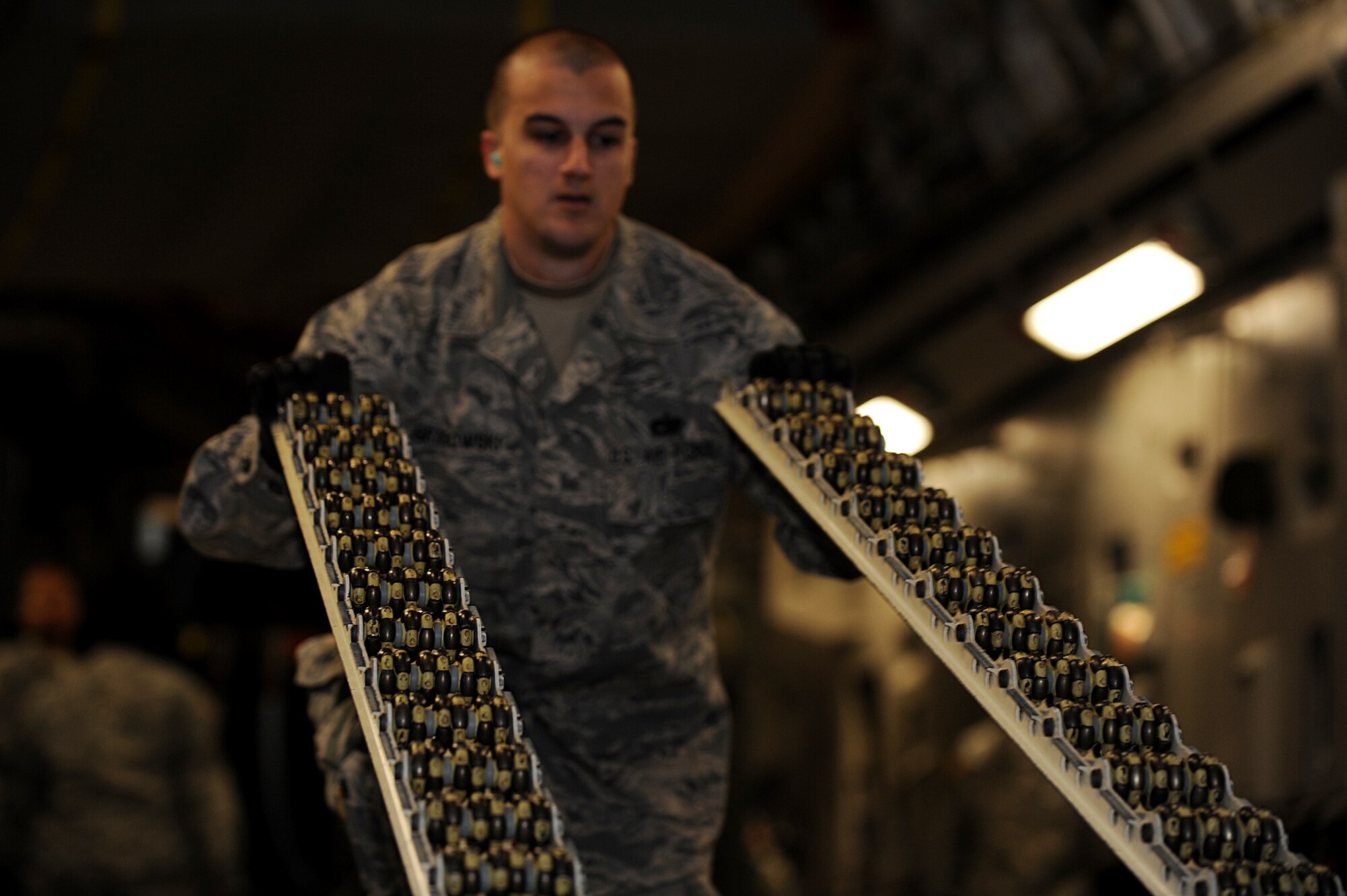 U.S. Air Force Staff Sgt. Craig Grabowski, 633rd Logistics Readiness Squadron air terminal supervisor, lifts rolling lanes from the floor of a C-17 Globemaster III during a joint unloading operation at Langley Air Force Base, Va., Oct. 23, 2013. The operation paired Airmen with Soldiers from the 622nd Movement Control Detachment from Fort Eustis, Va., in an effort to teach Soldiers large airframe training procedures. (U.S. Air Force photo by Staff Sgt. Jarad A. Denton/Released)