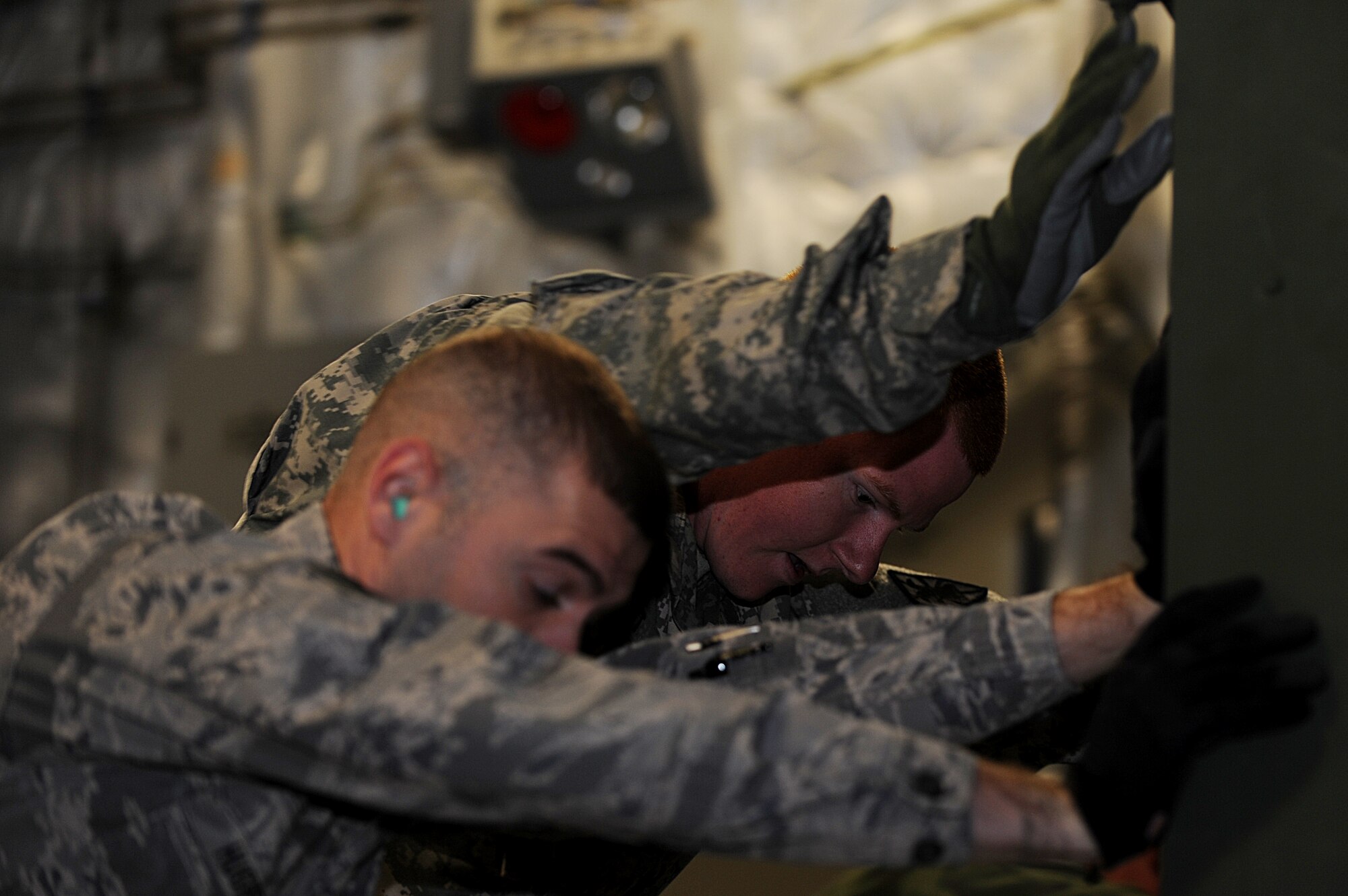 U.S. Air Force Staff Sgt. Andrew Hughes, left, 633rd Logistics Readiness Squadron air terminal supervisor, pushes cargo with U.S. Army Pvt. Christopher Mott, from the 622nd Movement Control Detachment from Fort Eustis, Va., during a joint C-17 Globemaster III unloading operation at Langley Air Force Base, Va., Oct. 23, 2013. The mission gave both the Soldiers and Airmen a new perspective on joint-service operations. (U.S. Air Force photo by Staff Sgt. Jarad A. Denton/Released) 