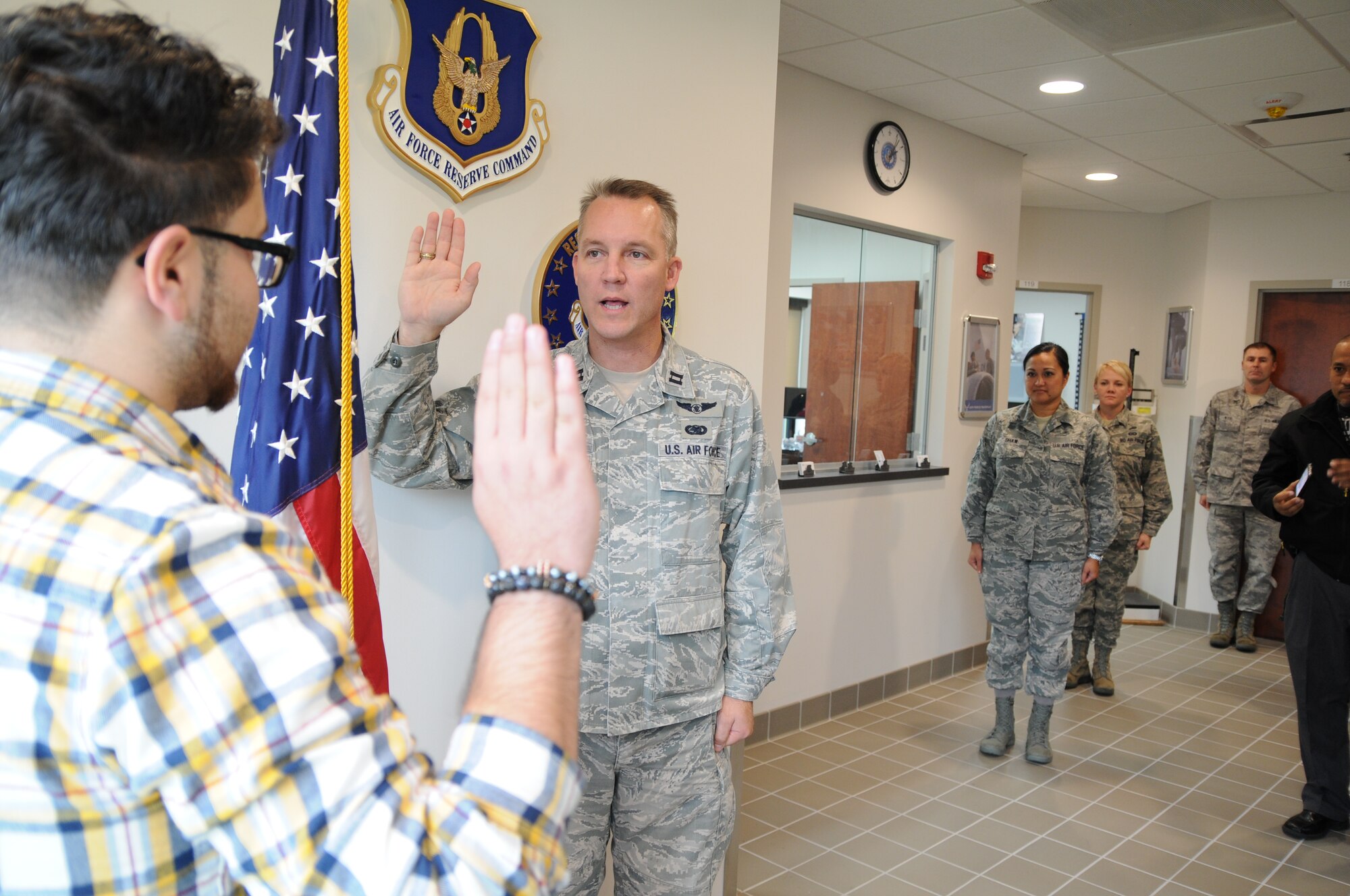 U.S. Air Force Reserve Capt. Scott Allen (center), 910th Mission Support Group Executive Officer, leads 19-year-old Efrain Maldonado, an Air Force Reserve recruit, in the oath of enlistment here, Oct. 23, 2013. Maldonado graduated from Youngstown Early College and is entering the the Financial Management Air Force career field. This enlistment was the first in Youngstown Air Reserve Station's new recruiting services building. U.S. Air Force photo by Mr. Eric M. White.
