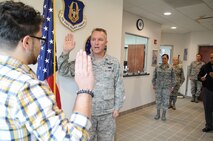 U.S. Air Force Reserve Capt. Scott Allen (center), 910th Mission Support Group Executive Officer, leads 19-year-old Efrain Maldonado, an Air Force Reserve recruit, in the oath of enlistment here, Oct. 23, 2013. Maldonado graduated from Youngstown Early College and is entering the the Financial Management Air Force career field. This enlistment was the first in Youngstown Air Reserve Station's new recruiting services building. U.S. Air Force photo by Mr. Eric M. White.