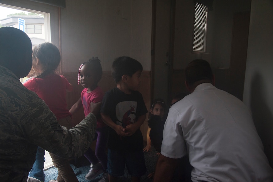 U.S. Air Force Staff Sgt. Phillip Burns, 23d Civil Engineer Squadron fire inspector, gives children a simulation of a household fire using a smoke machine at the Child Development Center at Moody Air Force Base, Ga., Oct. 9, 2013. The simulation taught children the importance of recognizing fires and how they should ‘stop, drop and roll’ to put out fires on their bodies. (U.S. Air Force photo by Airman Dillian Bamman/Released)