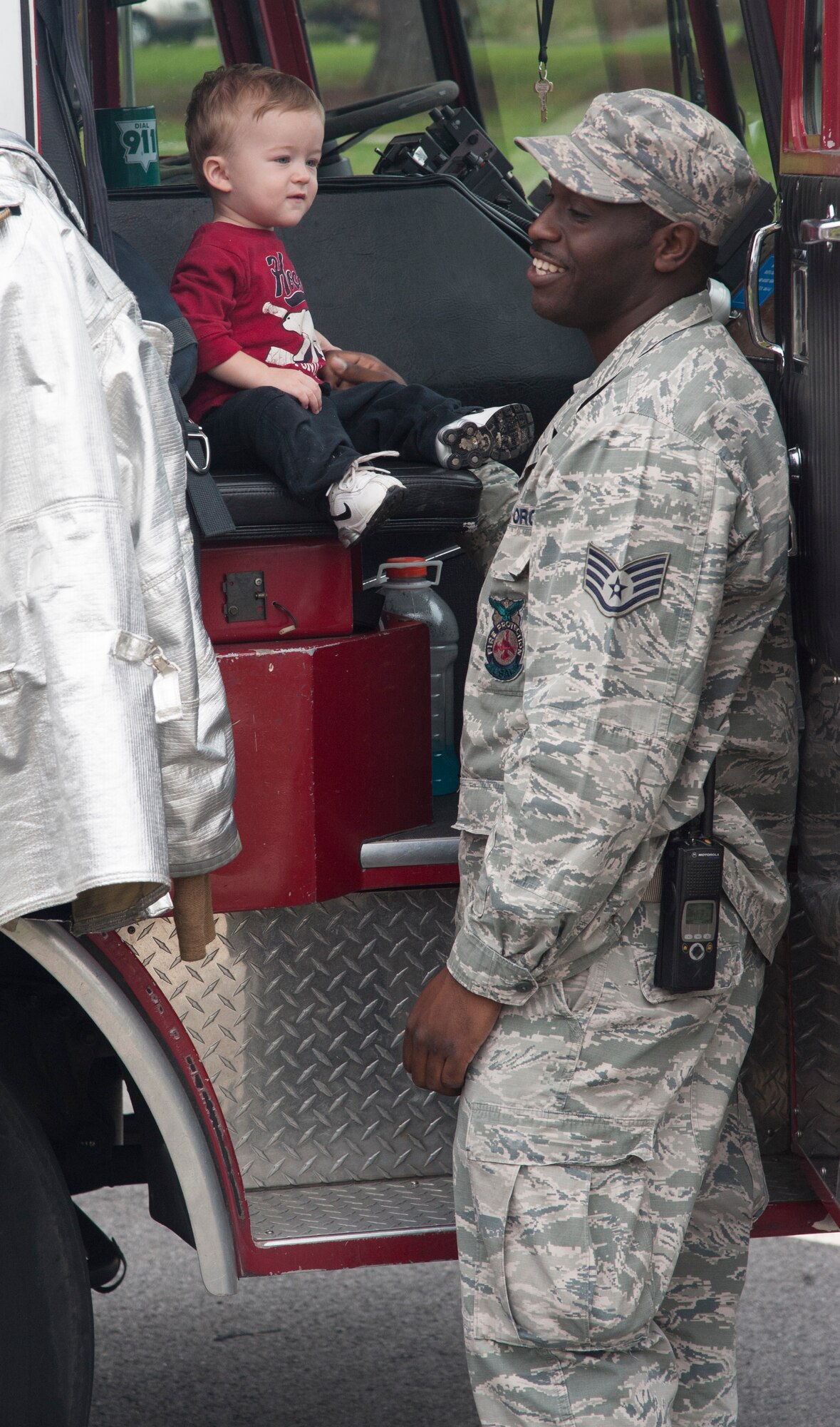 U.S. Air Force Staff Sgt. Phillip Burns, 23d Civil Engineer Squadron fire inspector, gives a child a tour of a fire truck at the Child Development Center at Moody Air Force Base, Ga., Oct. 9, 2013. National Fire Prevention Week began in 1922 to remember the Great Chicago Fire of 1871. (U.S. Air Force photo by Airman Dillian Bamman/Released)