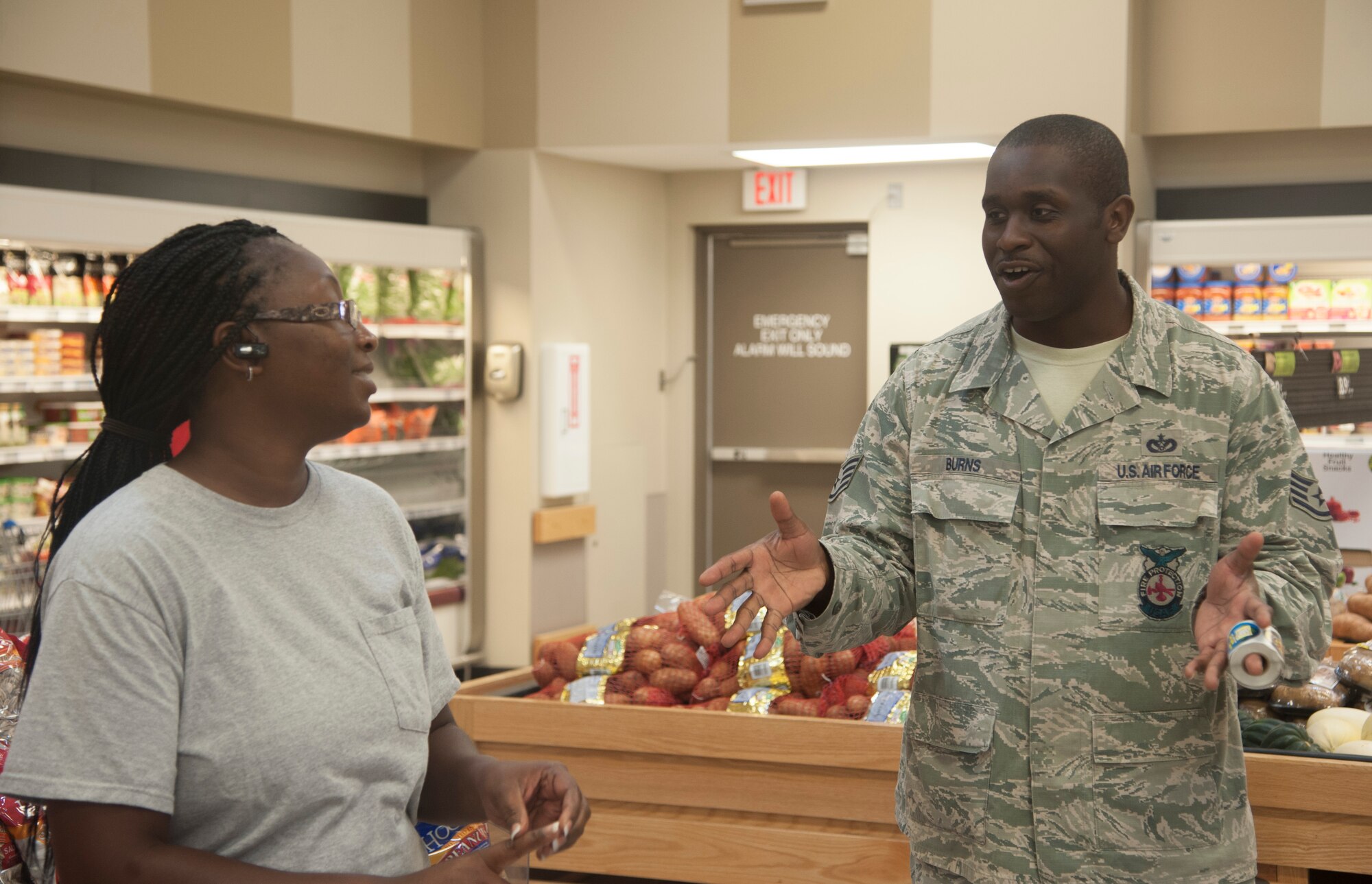 U.S. Air Force Staff Sgt. Phillip Burns, 23d Civil Engineer Squadron fire inspector, gives out fire prevention stickers to customers at the commissary on Moody Air Force Base, Ga., Oct. 8, 2013. This year, the theme of National Fire Prevention Week is “Prevent Kitchen Fires”. (U.S. Air Force photo by Airman Dillian Bamman/Released)