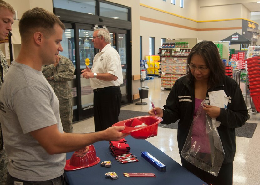 U.S. Air Force Staff Sgt. Jordan Gren, 23d Civil Engineer Squadron firefighter, speaks to a customer about preventing kitchen fires at the commissary on Moody Air Force Base, Ga., Oct. 8, 2013. Fire Prevention Week is designed to raise fire safety awareness at Moody . (U.S. Air Force photo by Airman Dillian Bamman/Released)