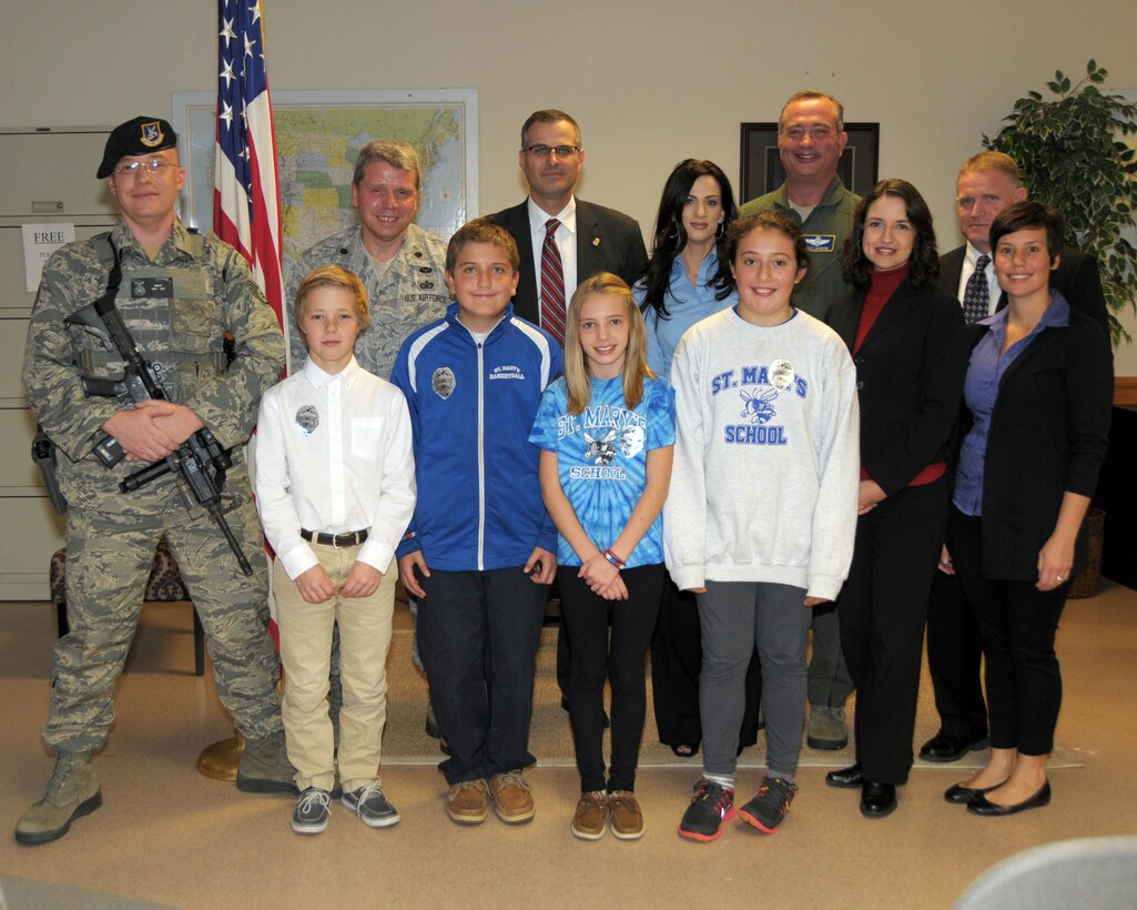Children from St. Mary's school  XXXX pose for a group photo with (left to right) Staff Sgt. Patrick Parkot, 914th Security Forces Squadron team member, LtCol. James Lawson, Commander 914th Security Forces Squadron, Mr. Brian Boetig, Special Agent in Charge, FBI Buffalo Division, Ms. XXXX  Teacher St. Mary's School, Col. Walter Gordon, Commander, 914th Airlift Wing, Special Agent Maureen Dempsey, Special Agent Darin Schultz, and Ms. Megan Calero, Family and Readiness Director, 914th Airlift Wing on October 23, 2013 at the Niagara Falls Air Reserve Station, NY. The children raised awareness of the plight of homeless Veterans in Western New York and also were recognized by the FBI for their genuine efforts in improving their community. (U.S. Air Force photo by Mr. Peter Borys)