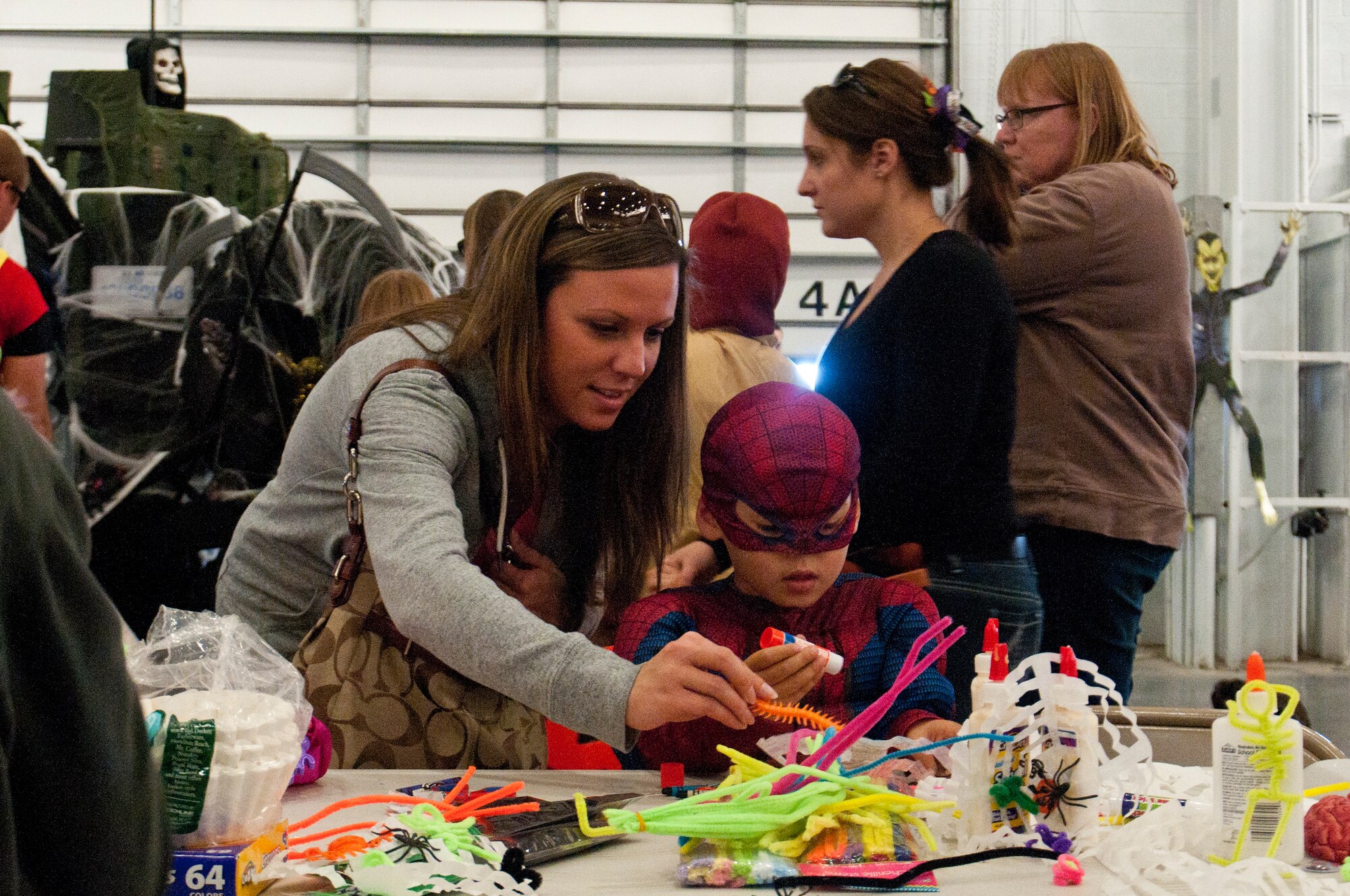 Erika Walsh creates a Halloween-themed craft with her son, Kaiden, at the 90th Security Forces Group Trunk-or-treat in Bldg. 1501, Oct. 19, 2013. Kaiden is the son of Senior Airman Kevin Walsh, 90th Security Forces Squadron. The Trunk-or-treat is a 90th SFG Top 4-sponsored event for defenders to celebrate Halloween with their families in a safe environment among their peers. (U.S. Air Force photo by Airman 1st Class Jason Wiese)