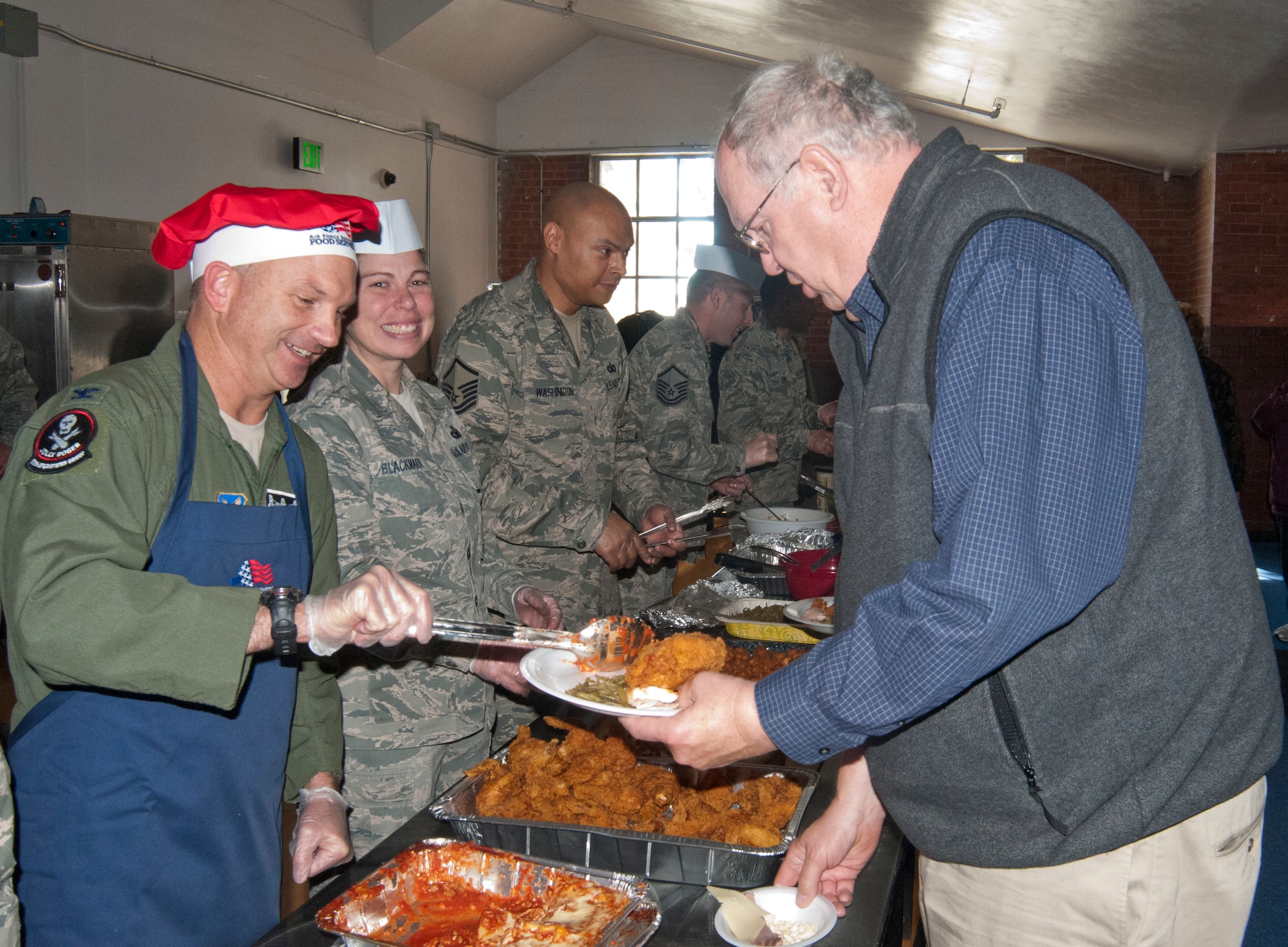 Col. Donnie Holloway, 90th Operations Group commander, serves food to Retired Master Sgt. Jack Colvin, 90th Logistics Readiness Squadron quality assurance representative, during a luncheon held in honor of civilian employees Oct. 18, 2013. (U.S. Air Force photo by Airman 1st Class Jason Wiese)