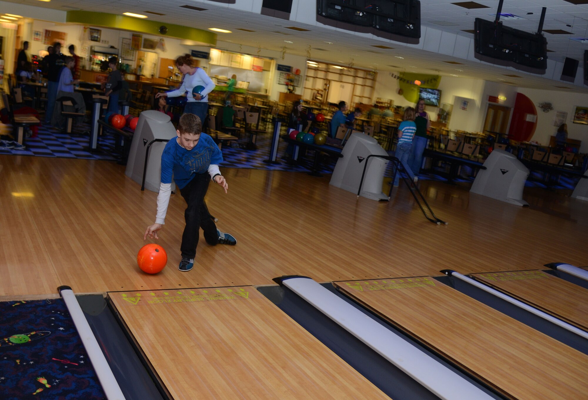 Members of the Exceptional Family Member Program take turns bowling during the EFMP family bowling night Oct. 21, 2013, on RAF Mildenhall, England. The EFMP family bowling night is held quarterly along with other activities. The EFMP is designed for Airmen from RAF Mildenhall, RAF Lakenheath and RAF Feltwell who have dependents with exceptional medical or educational needs. (U.S. Air Force photo by Airman 1st Class Kelsey Waters/Released)