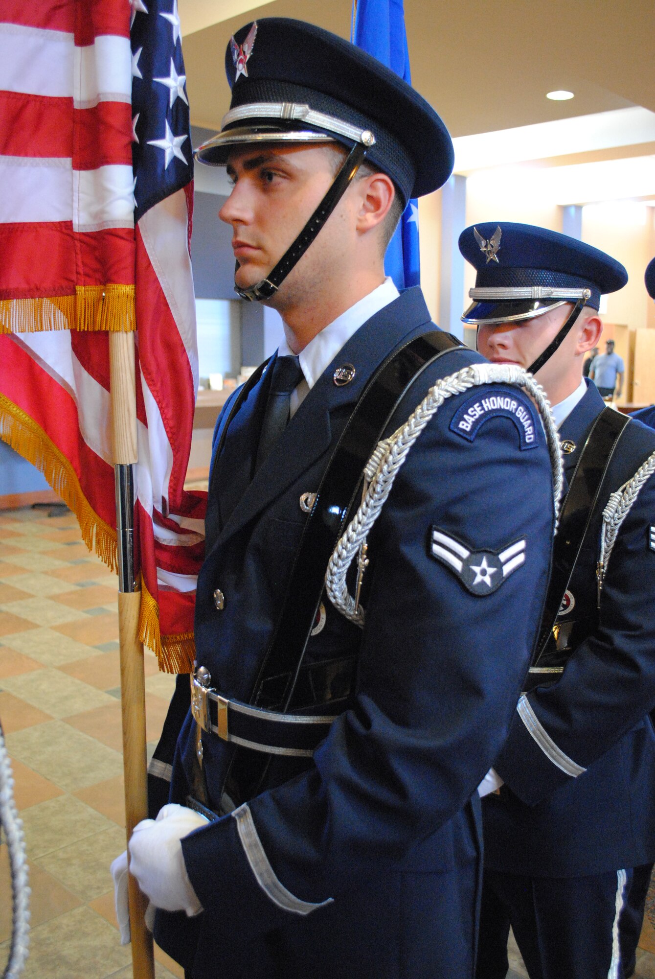 With the American flag by his side, Airman 1st Class Joshua Weaver awaits for the signal to lead an honor guard detail down the aisle and present the colors during an Air Force retirement ceremony Aug. 27, 2013, at the Community Activity Center at Grand Forks Air Force Base, N.D. The 23-year-old Airman from Selma, Ind., is the base’s Warrior of the Week for the third week of October 2013. (U.S. Air Force photo/Staff Sgt. Luis Loza Gutierrez) 
