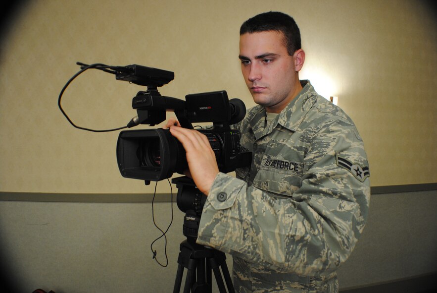 Airman 1st Class Joshua Weaver, adjusts the video camera lens while recording footage during the National Prayer Luncheon held Jan. 29, 2013, at the Northern Lights Club at Grand Forks Air Force Base, N.D.  Weaver, an Air Force public affairs broadcaster, was named the he base’s Warrior of the Week for the third week of October 2013, while serving as a ceremonial guardsman with the Grand Forks AFB Honor Guard. (U.S. Air Force photo/Staff Sgt. Luis Loza Gutierrez) 