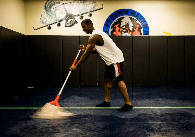 Senior Airman Martin Jackson, 628th Security Forces Squadron patrolman, uses a mop to clean any sweat, dirt or bacteria off of the Joint Base Charleston Phoenix Raven training facility mat to prevent infections or injuries after training Oct. 10, 2013, at Joint Base Charleston, S.C. Jackson and two other security forces members went through a three-week course at the JB Charleston Phoenix Raven facility to prepare them for the Phoenix Raven training course at the United States Air Force Expeditionary Center at Joint Base McGuire-Dix-Lakehurst, N.J. (U.S. Air Force photo/ Senior Airman Dennis Sloan)