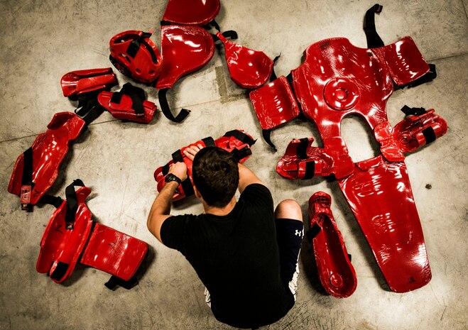 Phoenix Raven Redman gear is spread out on the floor of the Joint Base Charleston Phoenix Raven training facility while a Raven member puts the gear on before a Redman training session Oct. 10, 2013. The Redman suit consists of more than ten pieces which protect the “aggressor” against strikes from the trainees. (U.S. Air Force photo/ Senior Airman Dennis Sloan)
