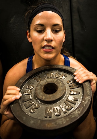 Airman 1st Class Marisa Placie, 628th Security Forces Squadron patrolman, holds a 25 pound weight out in front of herself while performing a wall stand during a Phoenix Raven training session Oct. 10, 2013, at Joint Base Charleston, S.C. Placie and two other security forces members went through a three-week course at the JB Charleston Raven facility to prepare them for the Phoenix Raven training course at the United States Air Force Expeditionary Center at Joint Base McGuire-Dix-Lakehurst, N.J. (U.S. Air Force photo/ Senior Airman Dennis Sloan)