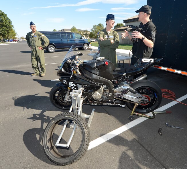 Tim Gooding (right), Army of Darkness motorcycle endurance racing team and  mechanic, talks with Tech. Sgt. David Grant, 3rd Airlift Squadron C-17A loadmaster, about the features of a BMW S1000RR race bike at Dover Air Force Base, Del., on Oct. 21, 2013. The racing team visited with Team Dover riders and discuss riding safely, teamwork and resiliency. (U.S. Air Force photo/Greg L. Davis)