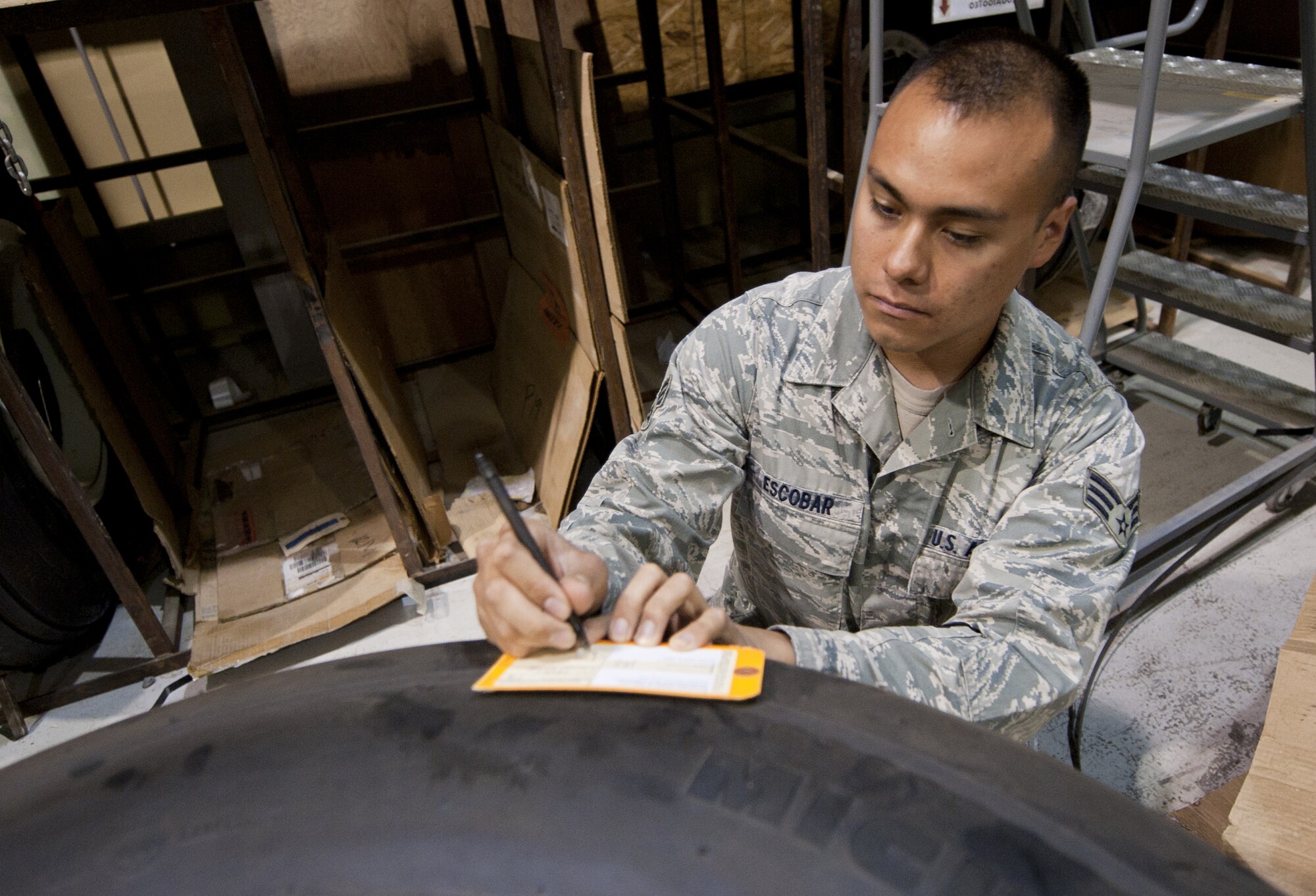 U.S. Air Force Senior Airman Tracy Escobar, 380th Expeditionary Logistics Readiness Squadron flightline supply journeyman, fills out a form to inventory an E-3 Sentry tire at an undisclosed location in Southwest Asia Oct. 8, 2013. The tire was stored and will be available in less than 30 minutes when an aircraft maintenance unit needs it. Escobar calls Huntington Beach, Calif., home and is deployed from Minot Air Force Base, N.D. (U.S. Air Force photo by Staff Sgt. Jacob Morgan)