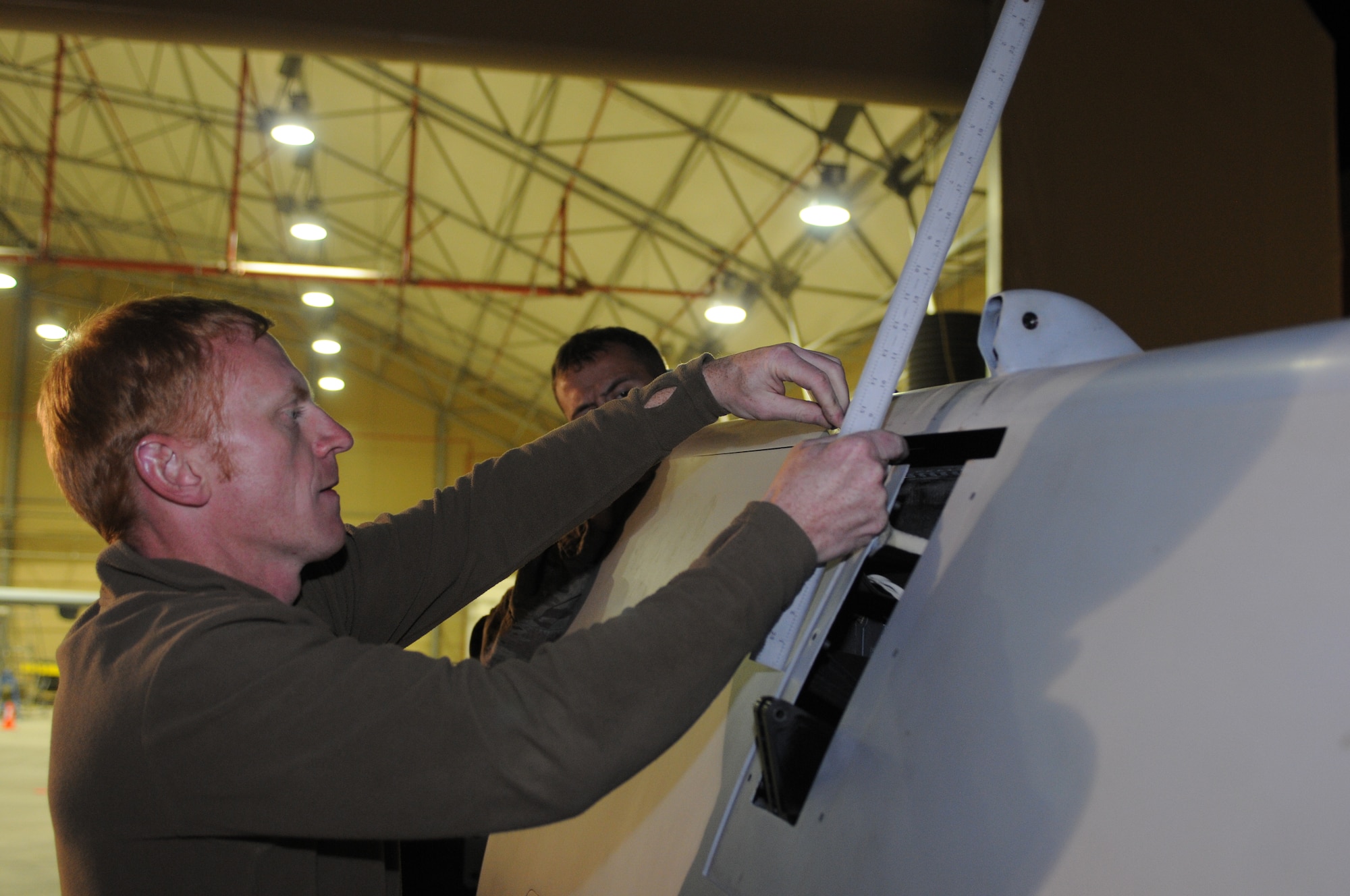 Royal Air Force Senior Aircraftman Jay Murcott, 451st Expeditionary Maintenance Squadron crewchief, assembles part of an MQ-9 Reaper wing before unloading it from a shipping container Oct. 18, 2013, at Kandahar Airfield, Afghanistan. The MQ-9 is being unloaded and constructed here. (U.S. Air Force photo by Senior Airman Jack Sanders)