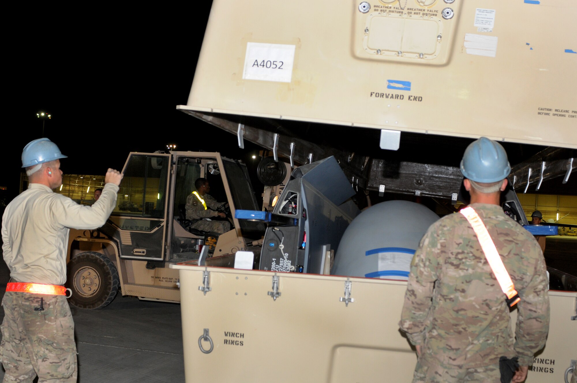 Airmen from the 451st Expeditionary Aircraft Maintenance Squadron open a shipping container holding an MQ-9 Reaper Oct. 18, 2013, at Kandahar Airfield, Afghanistan. The MQ-9 is being unloaded and constructed here. (U.S. Air Force photo by Senior Airman Jack Sanders)