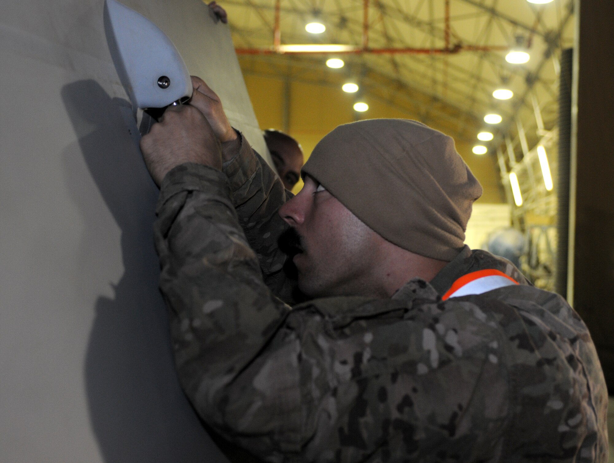 Airman 1st Class Alex Slobozien, 451st Expeditionary Maintenance Squadron crewchief, puts together parts of a wing for an MQ-9 Reaper as Staff Sgt. Ronald Zaragoza, 451st EMXS crewchief, holds the wing stabile Oct. 18, 2013, at Kandahar Airfield, Afghanistan. The MQ-9 is being unloaded and constructed here. (U.S. Air Force photo by Senior Airman Jack Sanders)