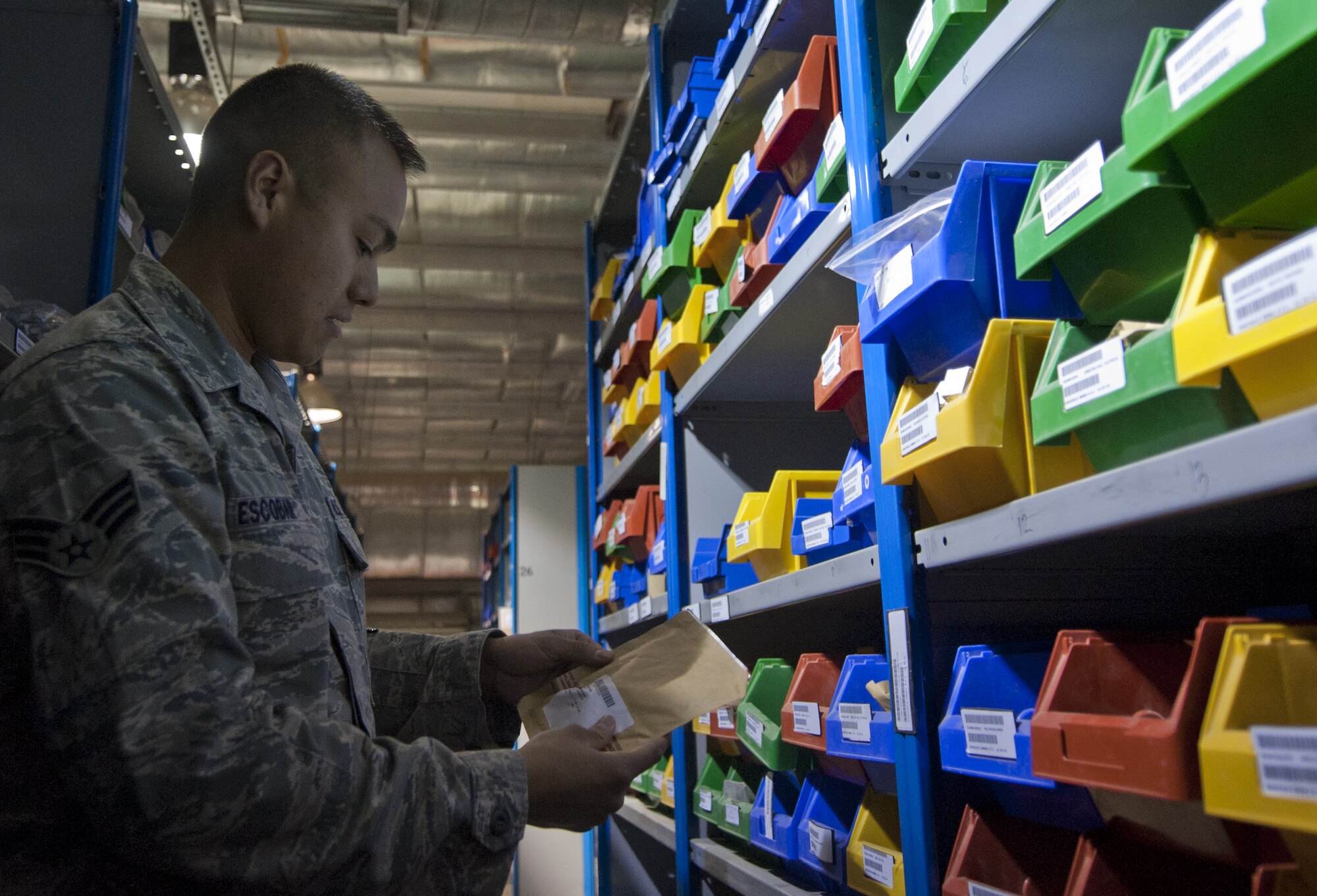 U.S. Air Force Senior Airman Tracy Escobar, 380th Expeditionary Logistics Readiness Squadron flightline supply journeyman, checks a package making sure it is stored correctly at an undisclosed location in Southwest Asia Oct. 8, 2013. Escobar uses a number and letter system to find small parts in a warehouse of more than 30,000 different items. Escobar calls Huntington Beach, Calif., home and is deployed from Minot Air Force Base, N.D. (U.S. Air Force photo by Staff Sgt. Jacob Morgan)
