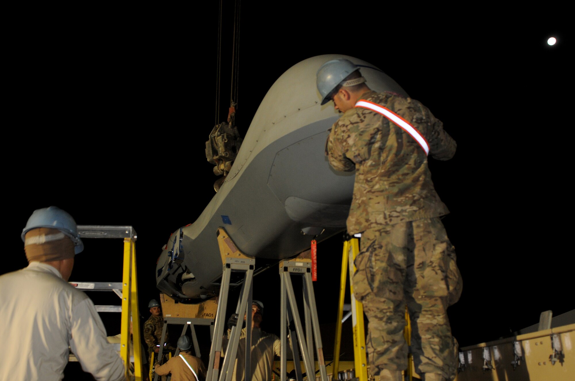 Airmen from the 451st Expeditionary Aircraft Maintenance Squadron unload an MQ-9 Reaper from a cargo container at Kandahar Airfield, Afghanistan, Oct. 18, 2013. The new MQ-9 will be assembled and added to the current fleet conducting the mission here. (U.S. Air Force photo by Senior Airman Jack Sanders)
