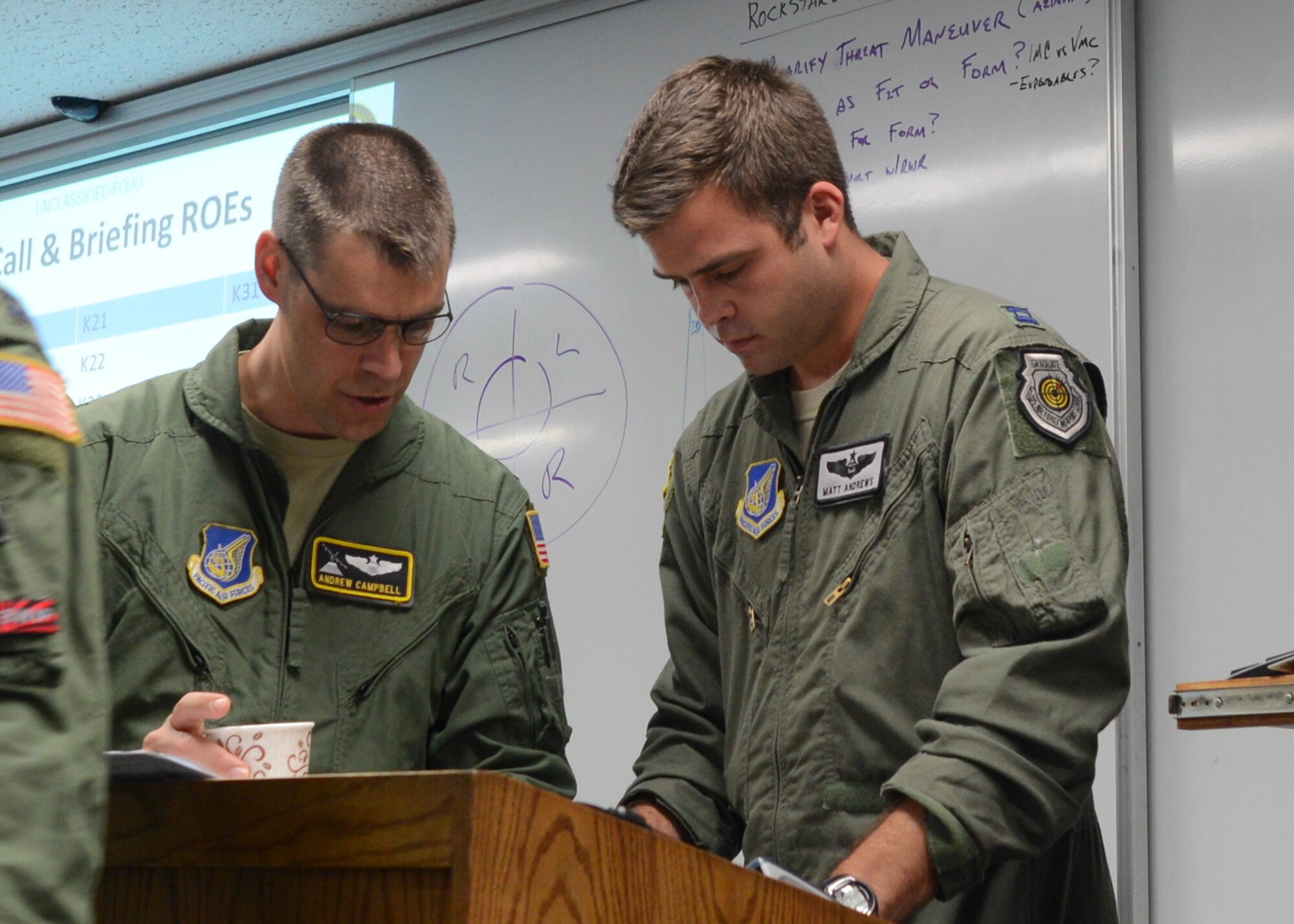 Lt. Col. Andrew Campbell, the director of operations, and Capt. Matthew Andrews, a mission commander, both with 36th Airlift Squadron, check the mission briefing for a large formation mission at Yokota Air Base, Japan, Oct. 22, 2013.  The surge tested wing’s capability to provide assistance anywhere within the Western Pacific region.  (U.S. Air Force photo by Airman 1st Class Soo C. Kim)
