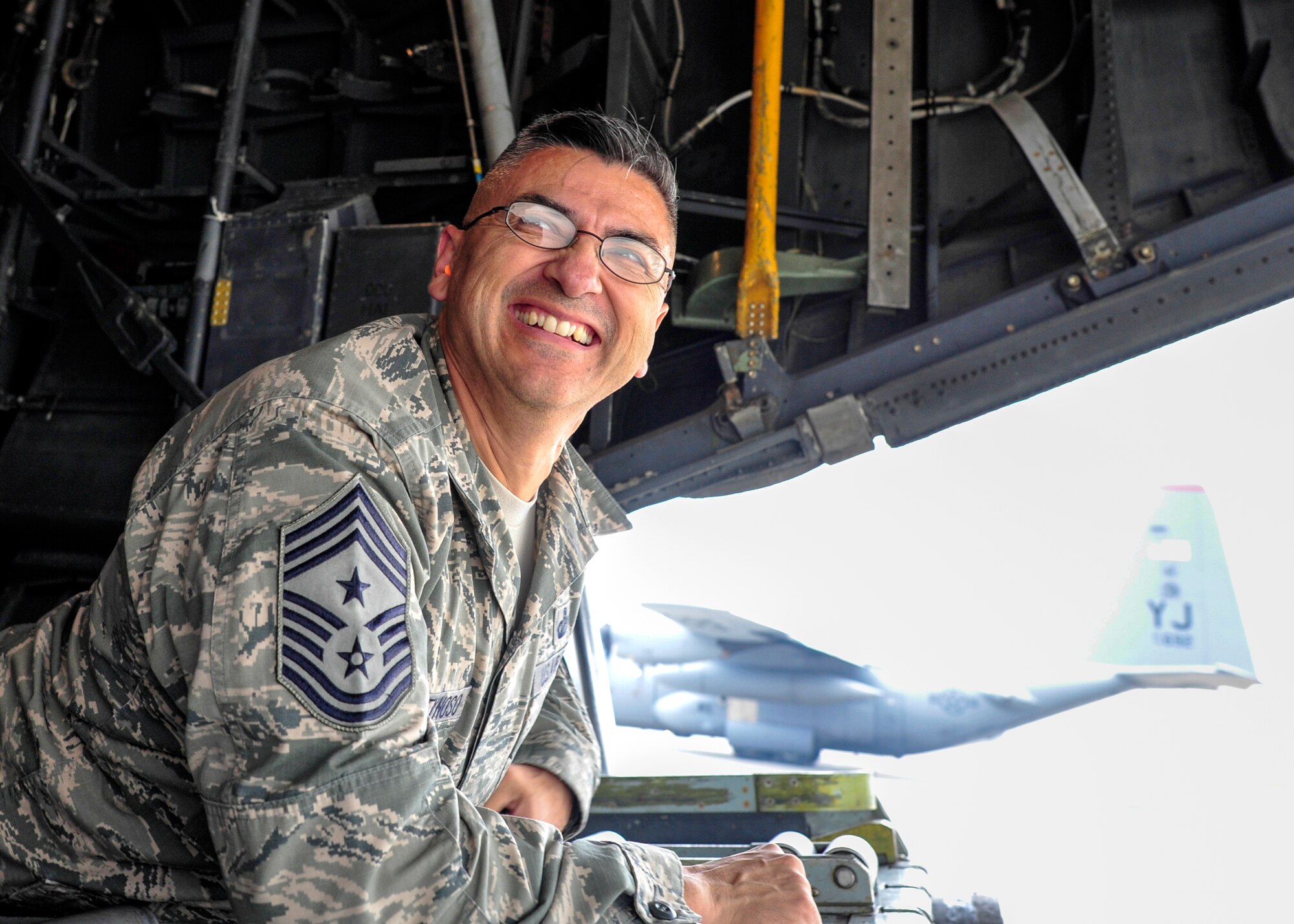 Chief Master Sgt. Manuel Roblesreynoso, the 374th Airlift Wing command chief, rides in a C-130 Hercules during a large formation mission at Yokota Air Base, Japan, Oct. 22, 2013.  Yokota showcased its ability to launch large-formation flights during when called to do so.  (U.S. Air Force photo by Airman 1st Class Soo C. Kim/released)