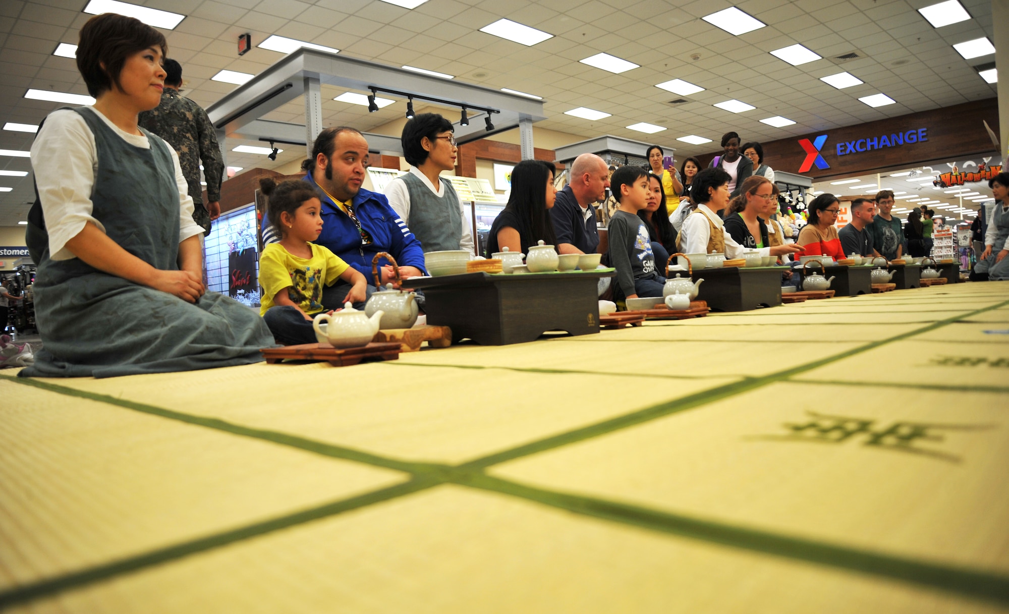 Participants in the Korean tea culture and customs lecture listen for directions on how to proceed during a traditional Korean tea ceremony at Osan Air Base, Republic of Korea, Oct. 23, 2013. There was an open invitation to anyone walking by the Exchange food court to have an opportunity to sit down, learn something new and enjoy a hot cup of green tea. (U.S. Air Force photo/Staff Sgt. Emerson Nuñez)
